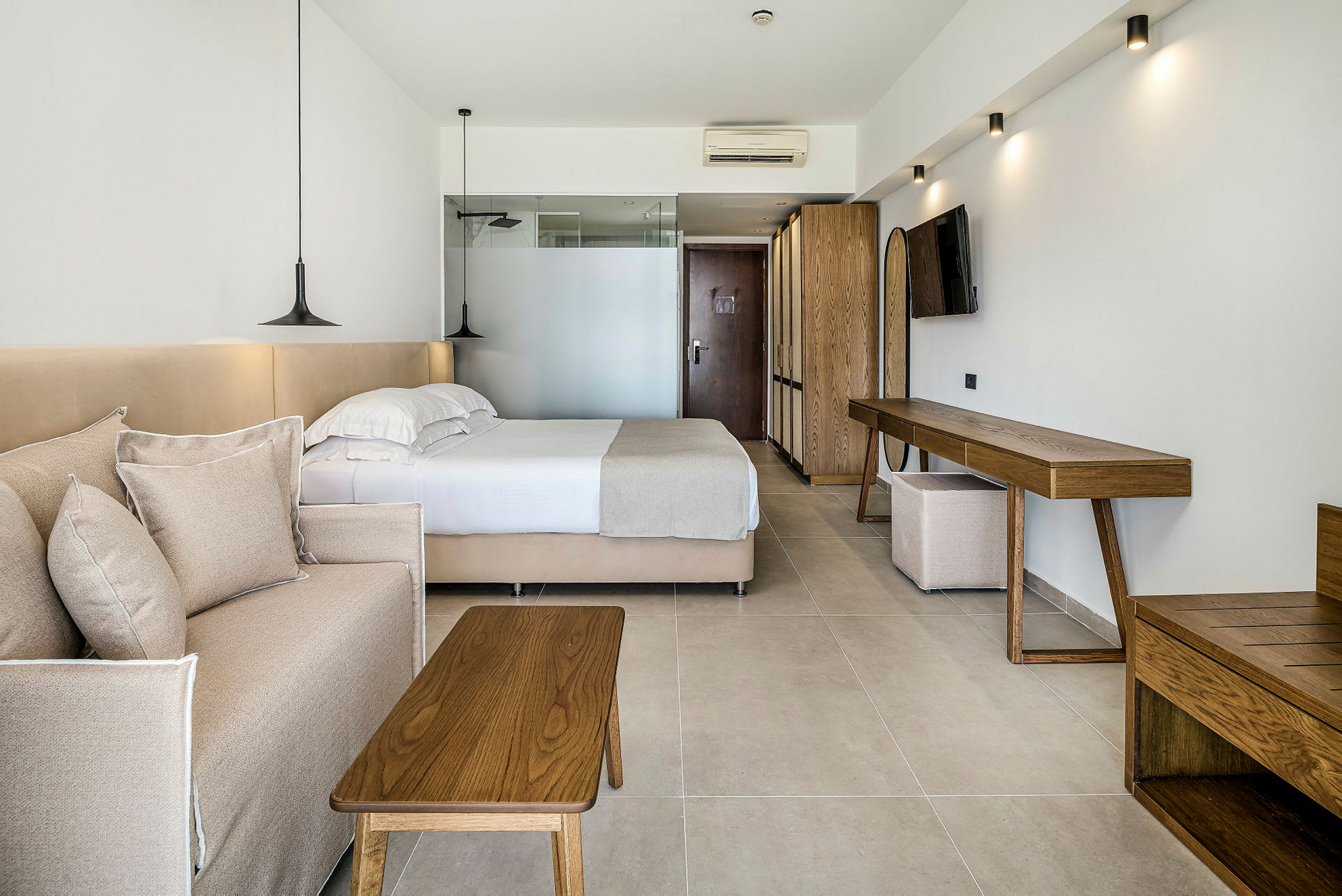 Ett hotellrum med en säng, en soffa och trämöbler. (AI-genererad text)