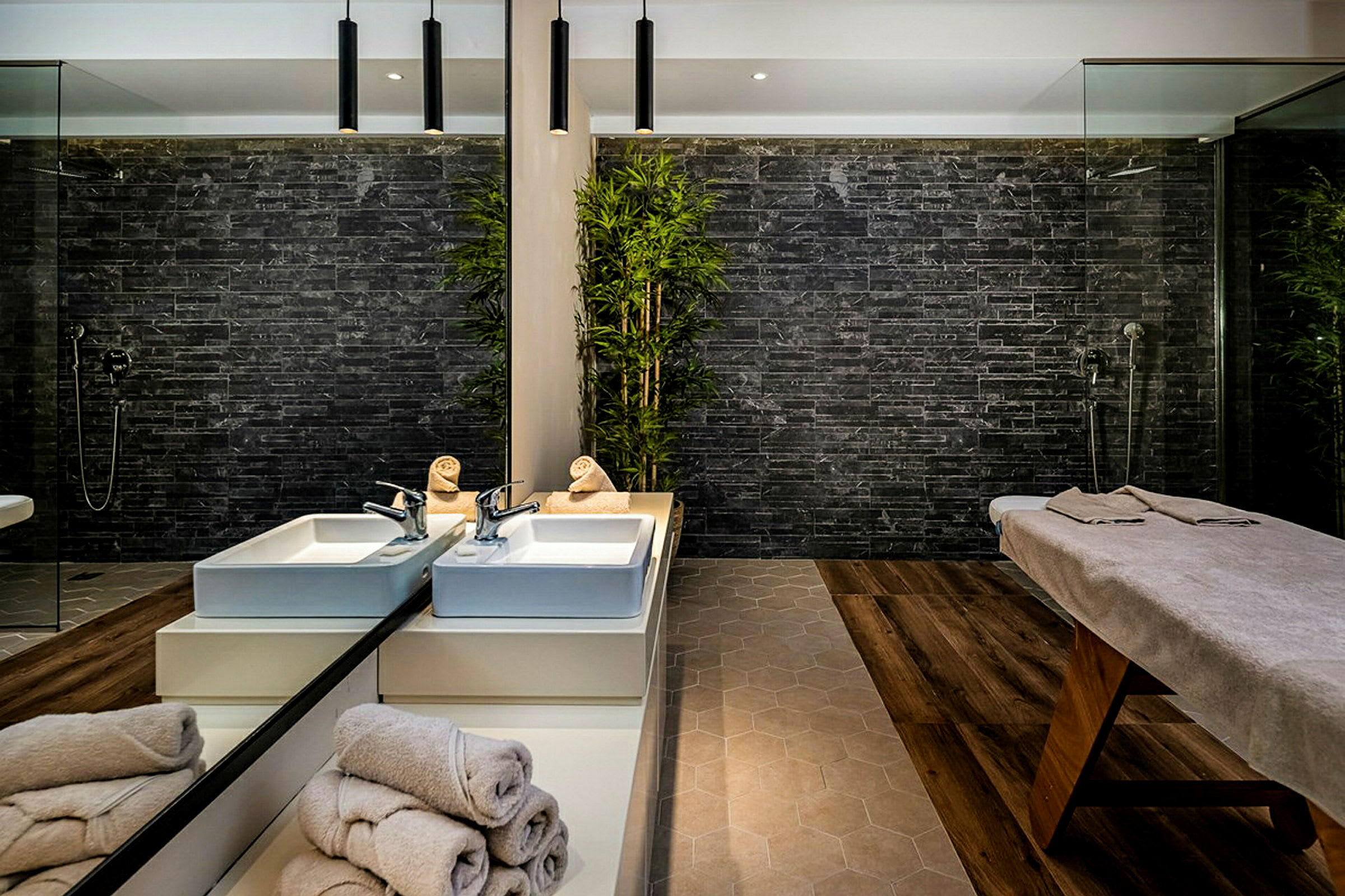 Ett modernt spa-område med en bädd för behandlingar och två tvättställ. (AI-genererad text)
