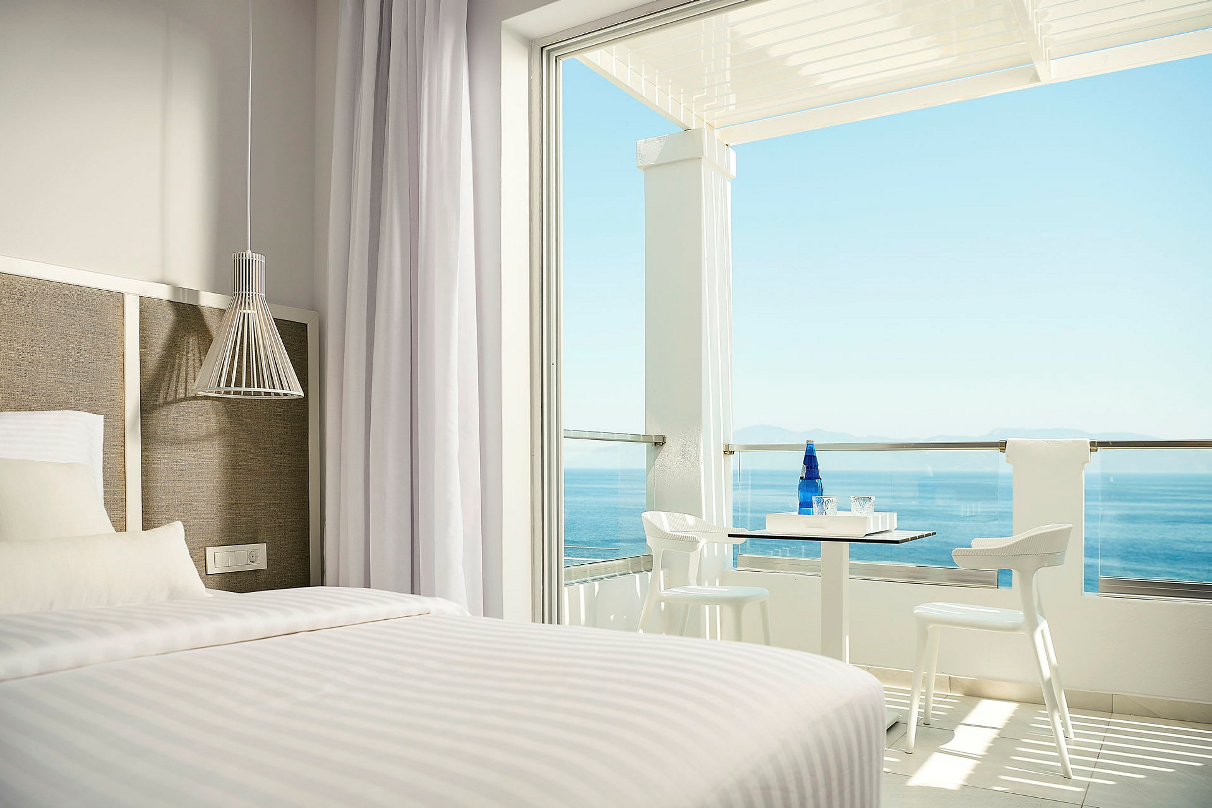 Hotellrum med säng och uteplats med havsutsikt. (AI-genererad text)
