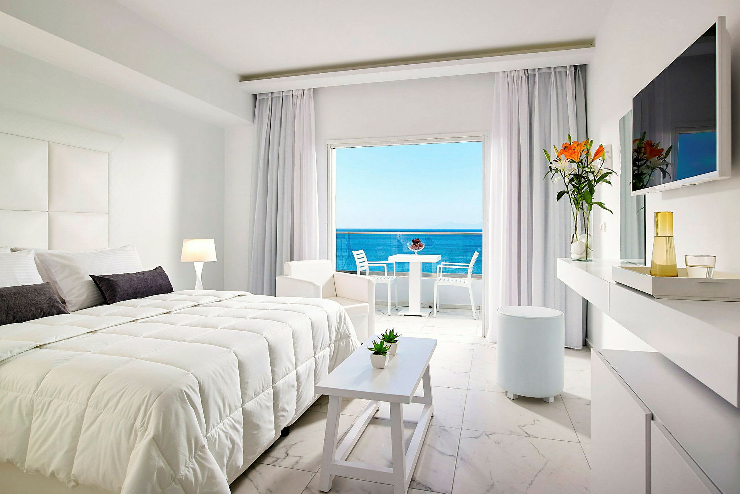 Modernt hotellrum med dubbelsäng, ljusa möbler och utsikt över havet. (AI-genererad text)