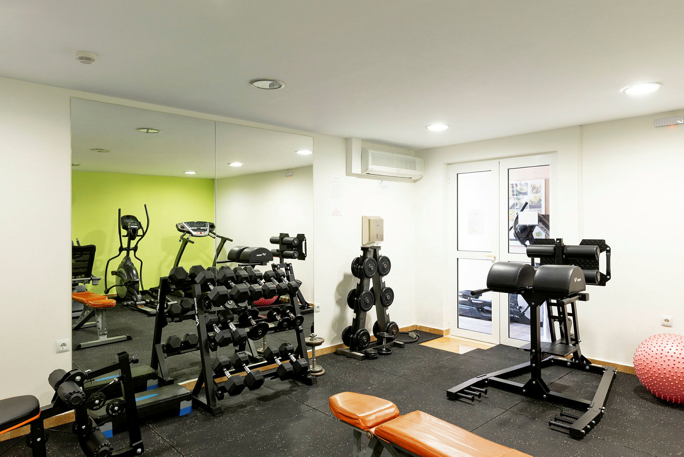 Ett gym med träningsutrustning såsom hantlar och konditionsmaskiner. (AI-genererad text)