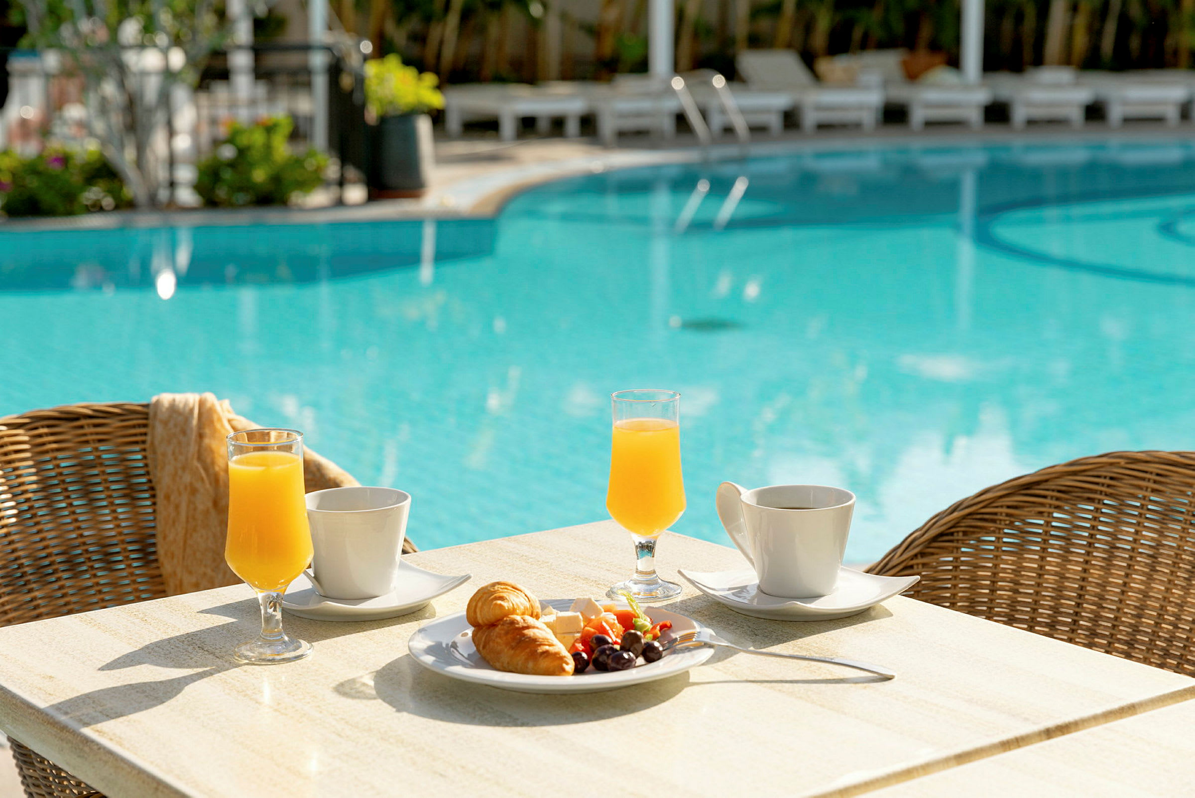 Ett bord med frukostmat vid en pool. (AI-genererad text)