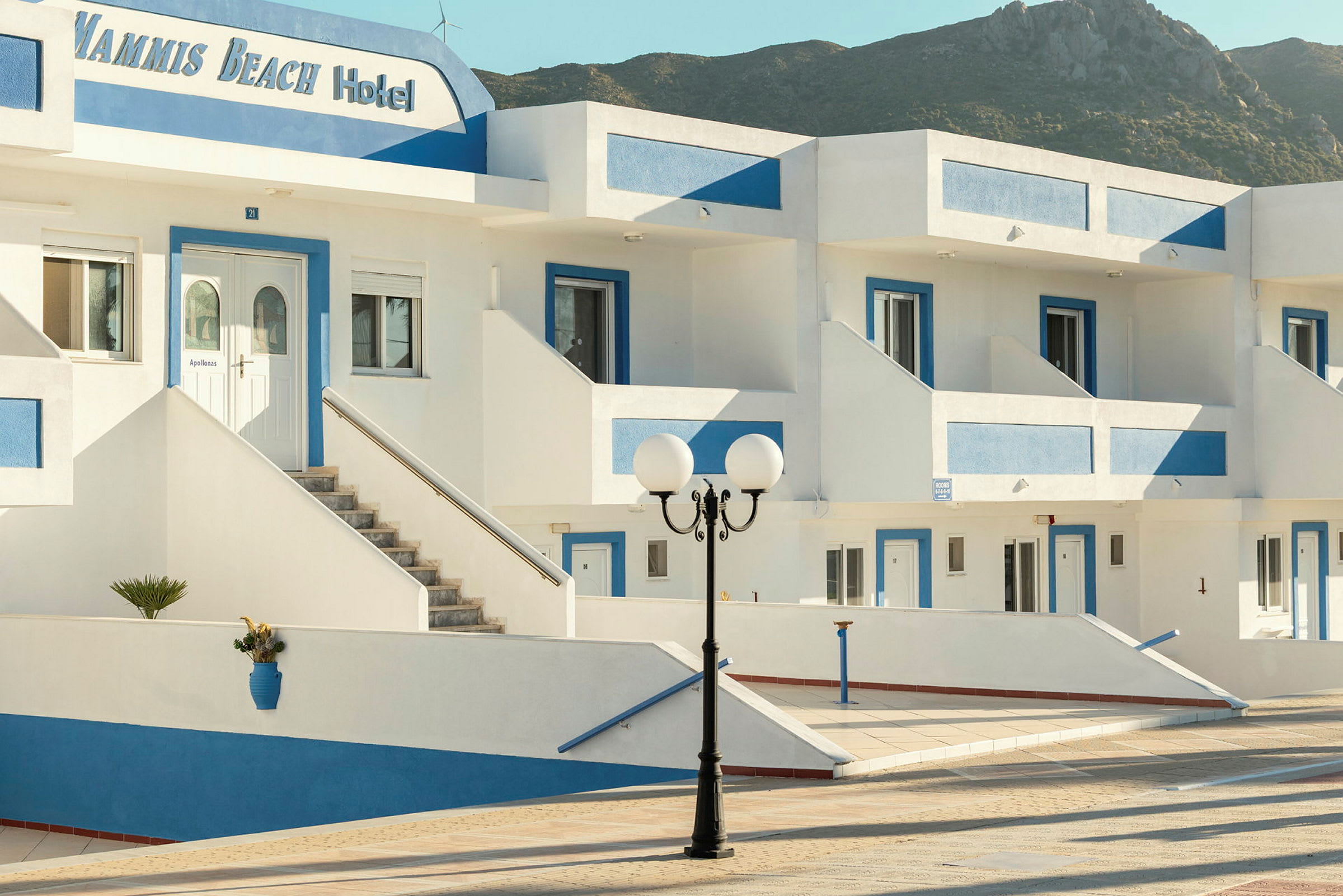 Bild av hotellbyggnad med vit fasad och blåa detaljer. (AI-genererad text)