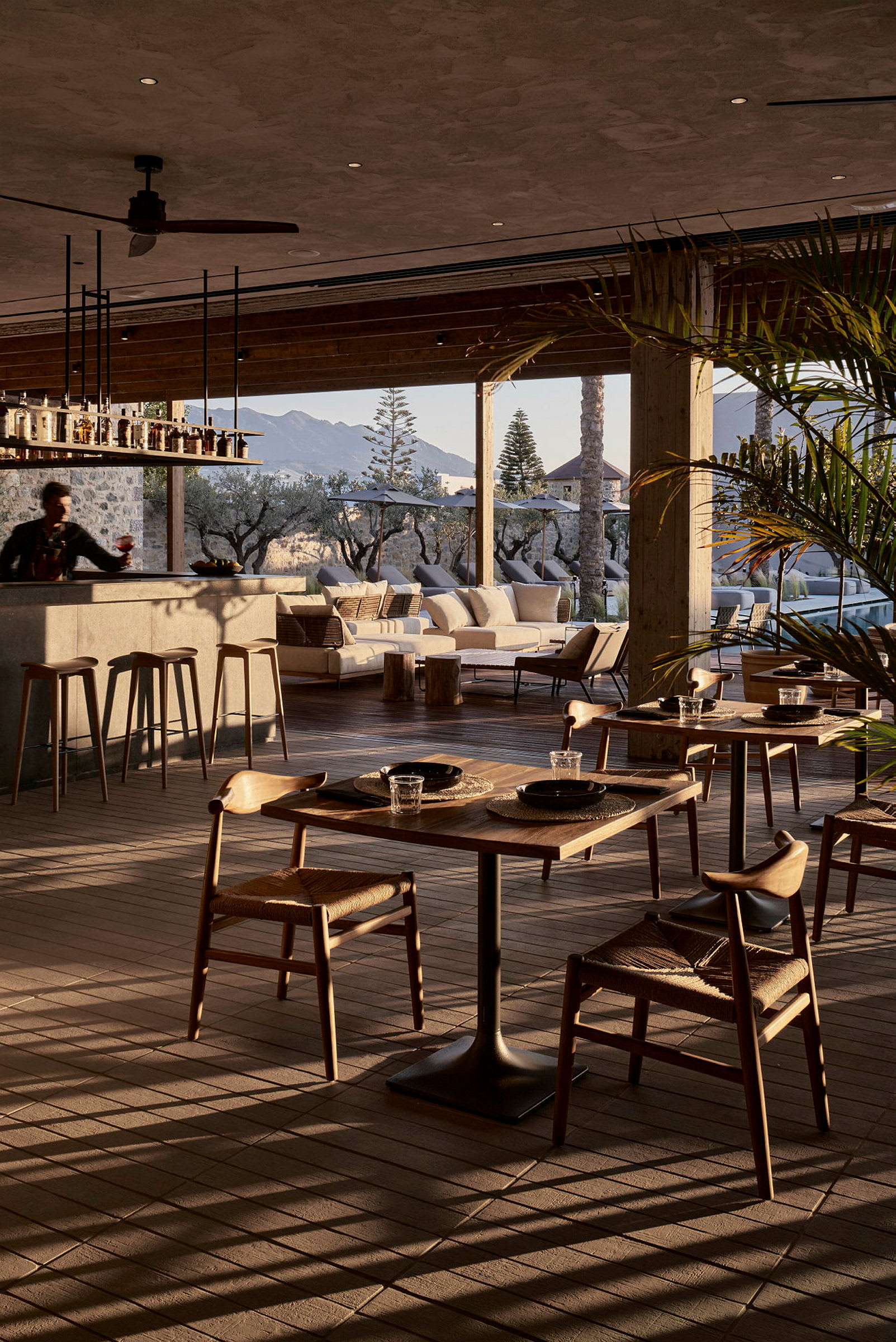En elegant restaurang med utsikt över ett utomhusområde och berg i bakgrunden. (AI-genererad text)