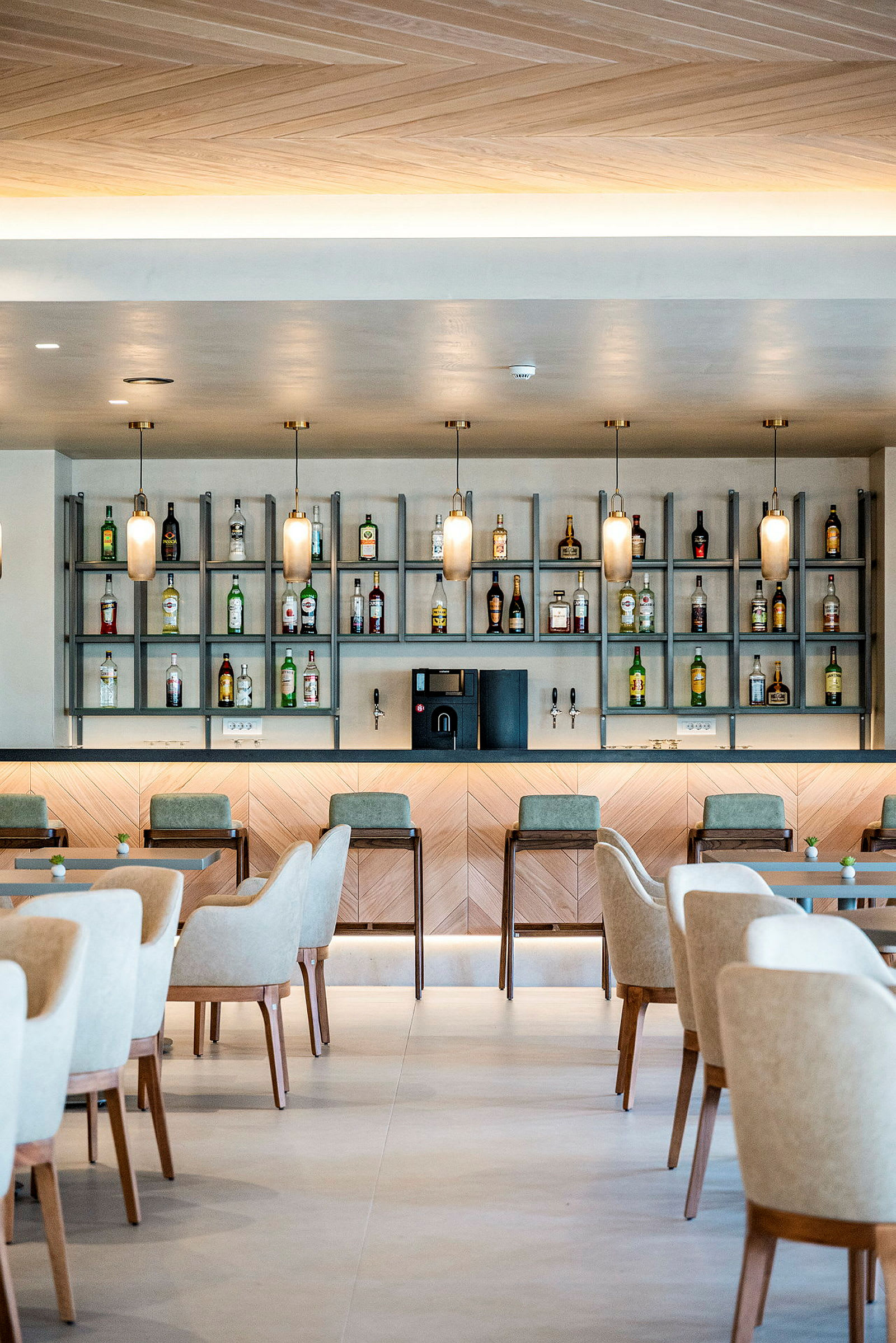 Bild av en elegant bar med flaskor, stolar och bord. (AI-genererad text)
