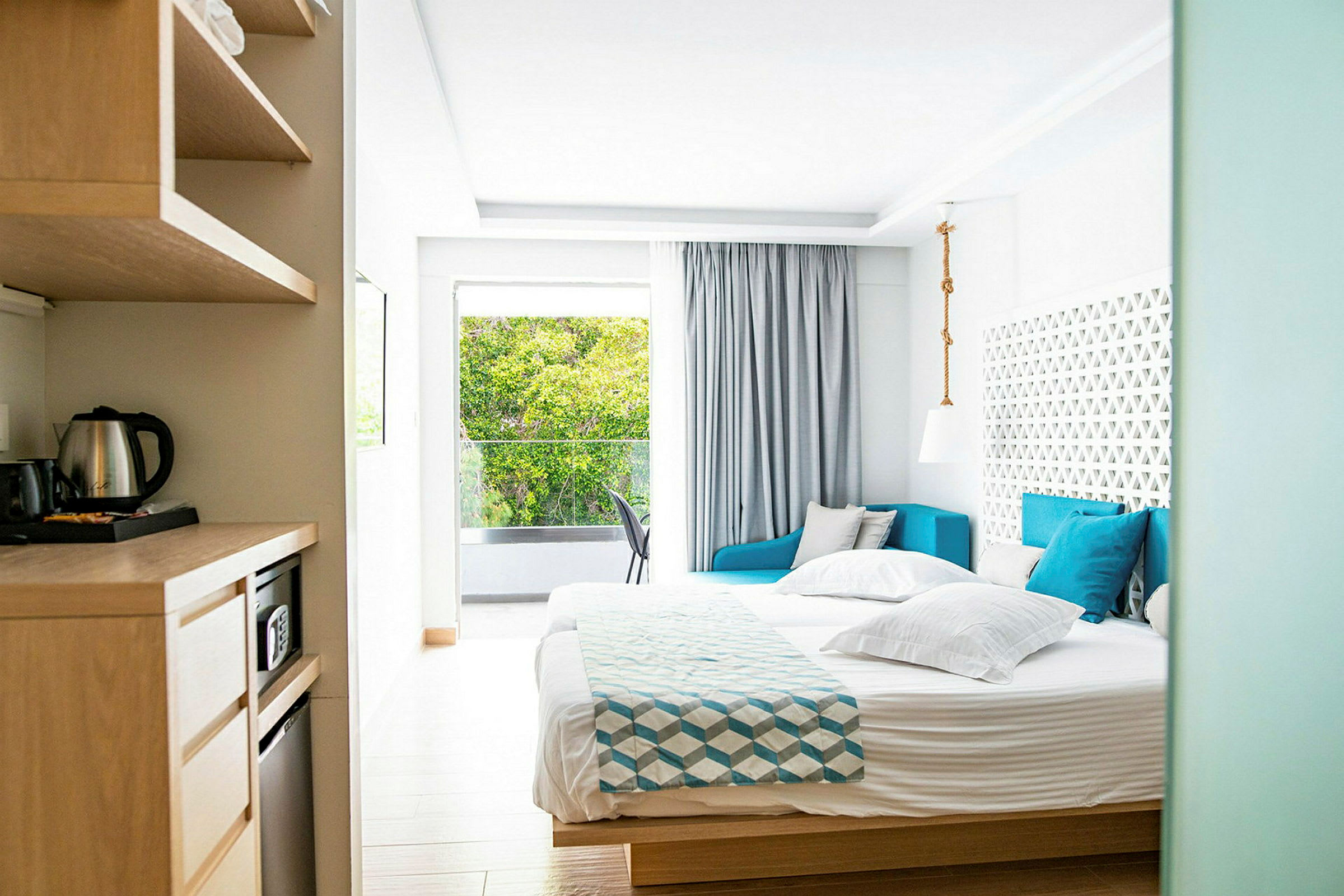 Bild av ett ljust hotellrum med säng, soffa och fönster med utsikt. (AI-genererad text)