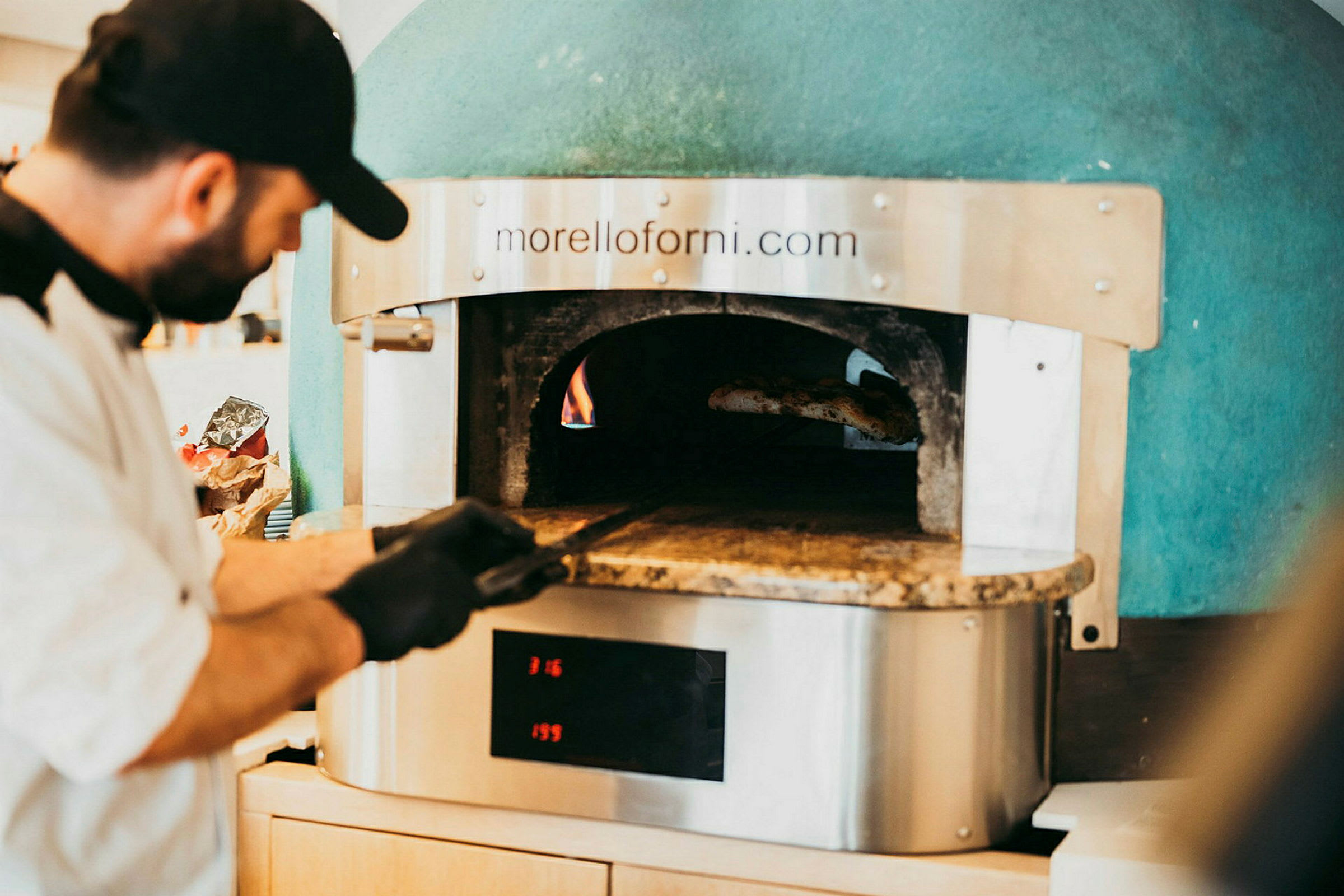 En vedeldad ugn med eld och pizzaspade. (AI-genererad text)