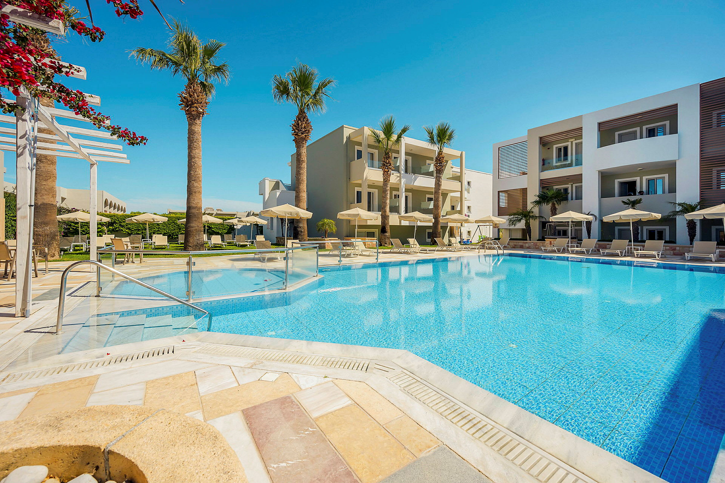 Utomhuspool och hotellbyggnad med solstolar. (AI-genererad text)