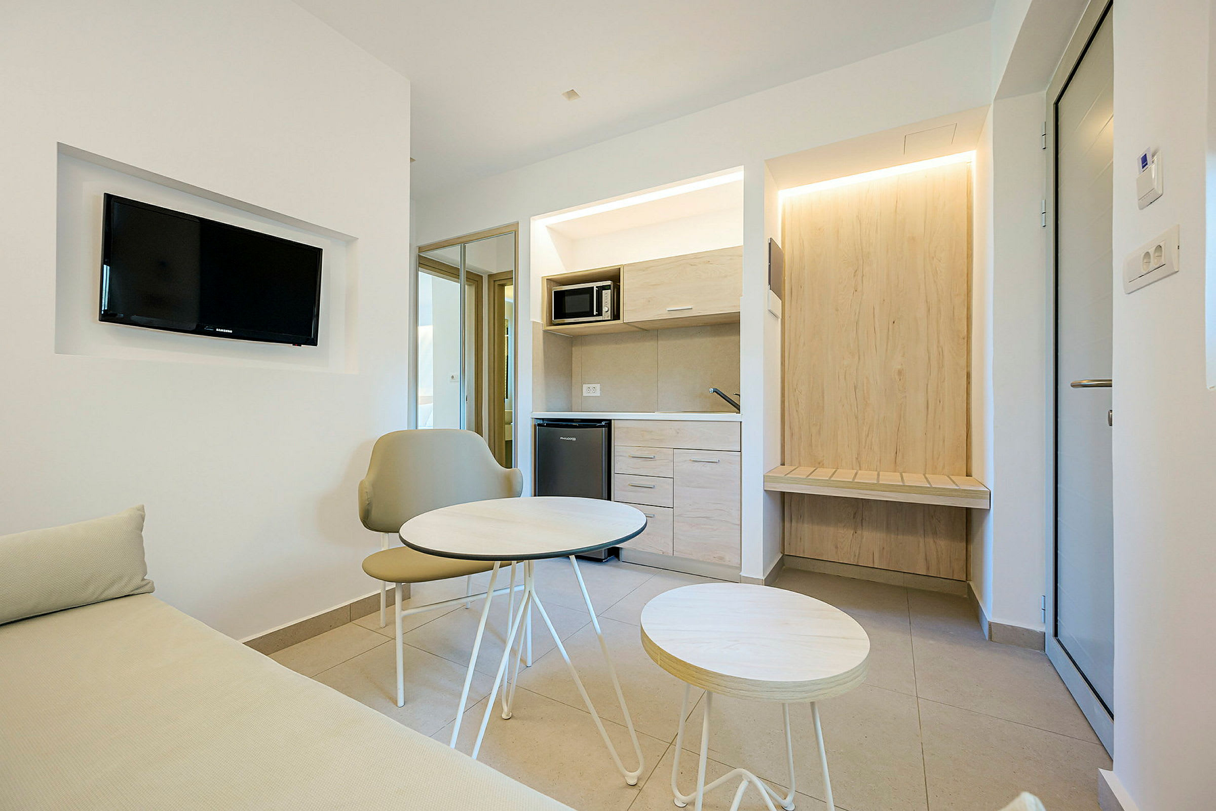 Ett modernt hotellrum med en liten sittgrupp och pentry. (AI-genererad text)
