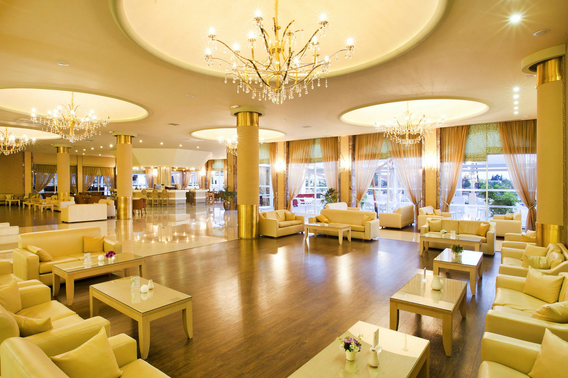 En hotellobby med bord, soffor, och ljuskronor. (AI-genererad text)