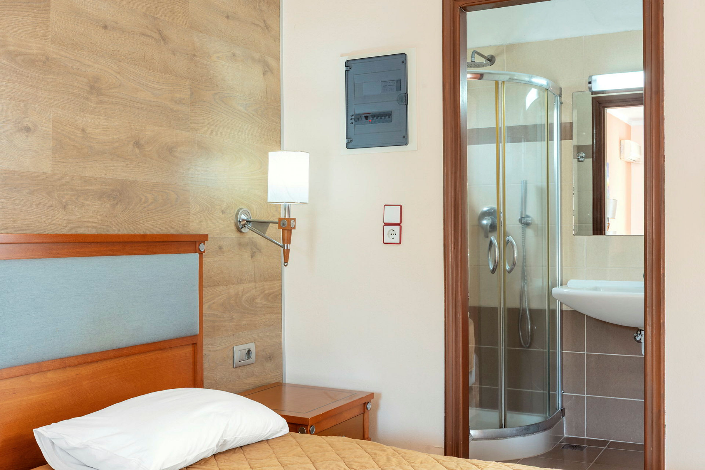 Hotellrum med säng och anslutande badrum. (AI-genererad text)