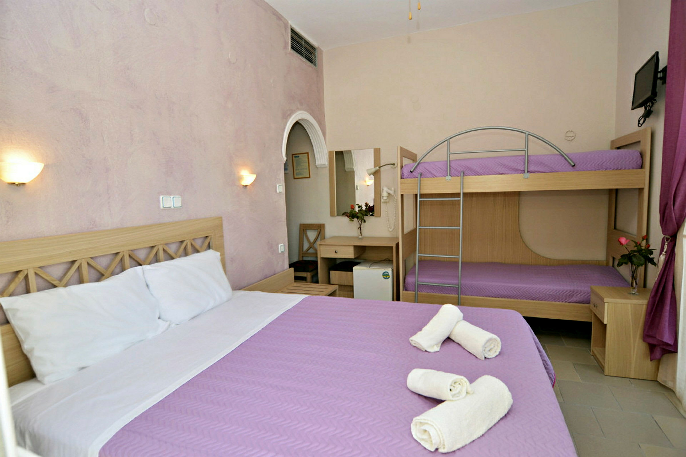 Hotellrum med dubbelsäng och våningssäng. (AI-genererad text)