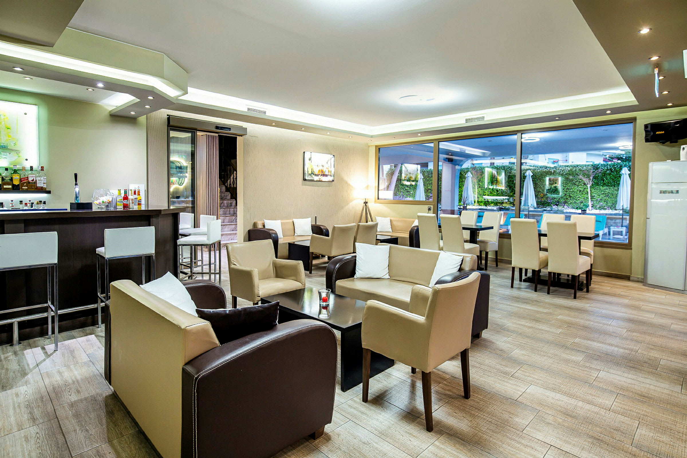 Interiör av en hotellbar med sittplatser och bord, samt en bar med stolar. (AI-genererad text)