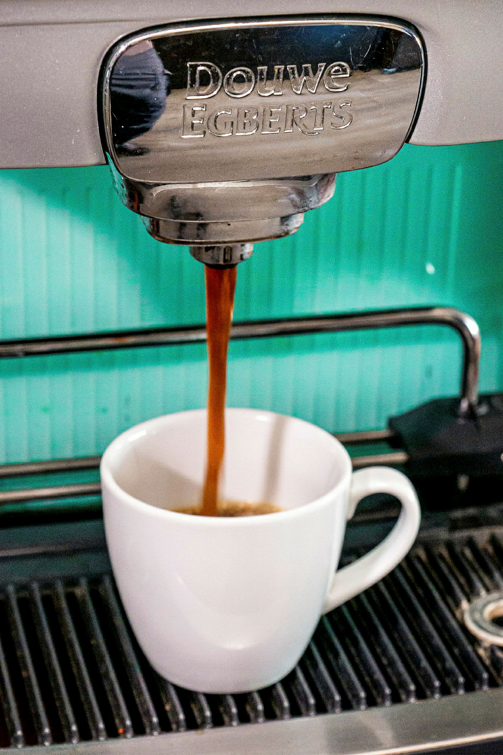 En kaffemaskin som brygger kaffe i en vit kopp. (AI-genererad text)