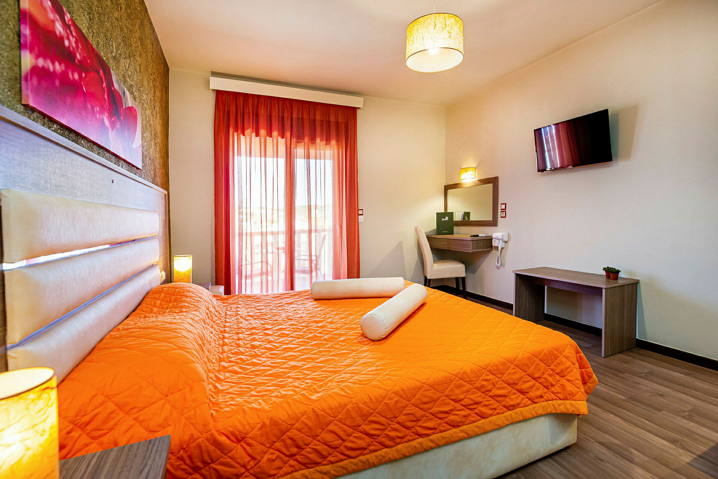 Ett hotellrum med orangea sängkläder och en sittplats vid skrivbordet. (AI-genererad text)