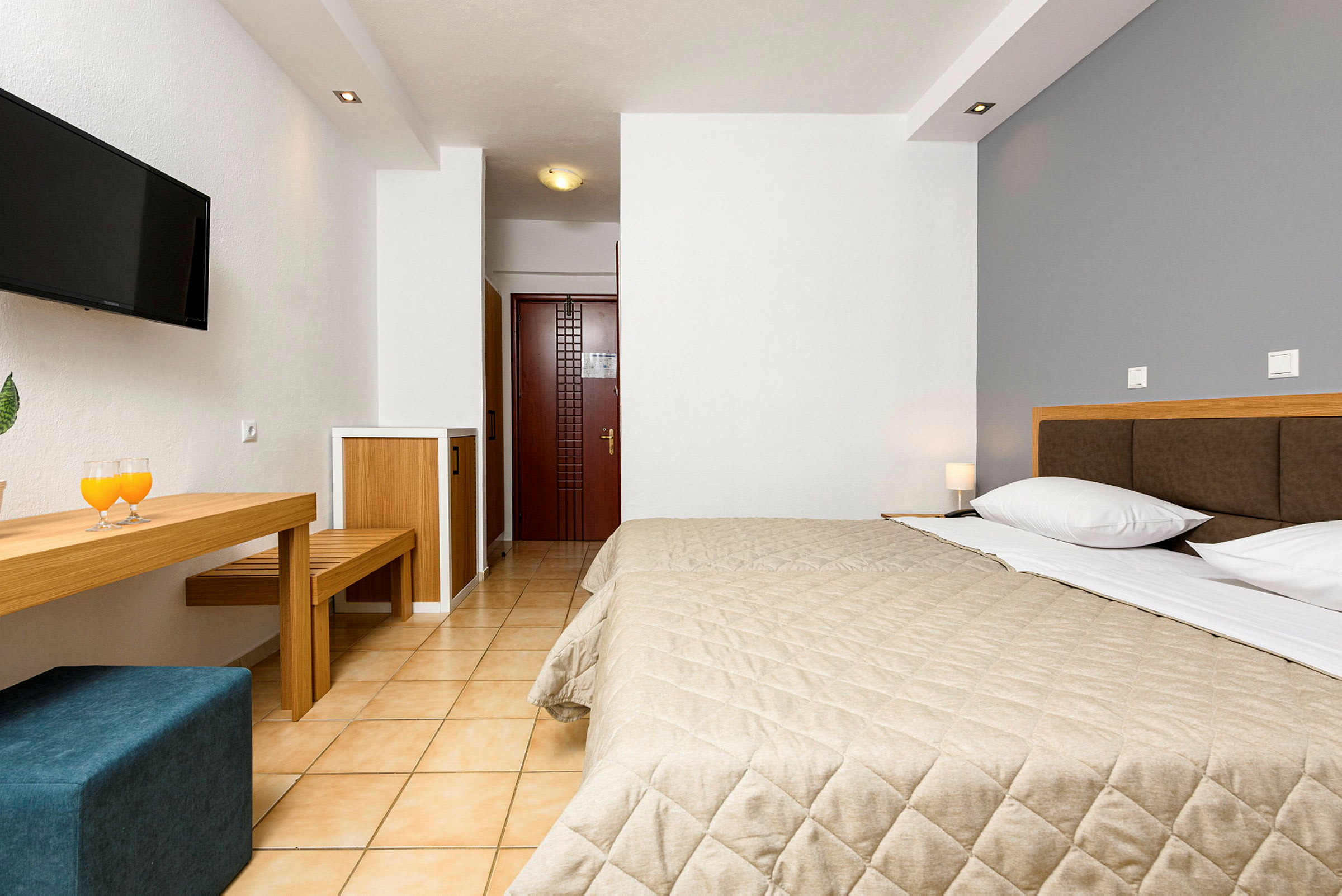 Ett hotellrum med en dubbelsäng, TV och skrivbord. (AI-genererad text)