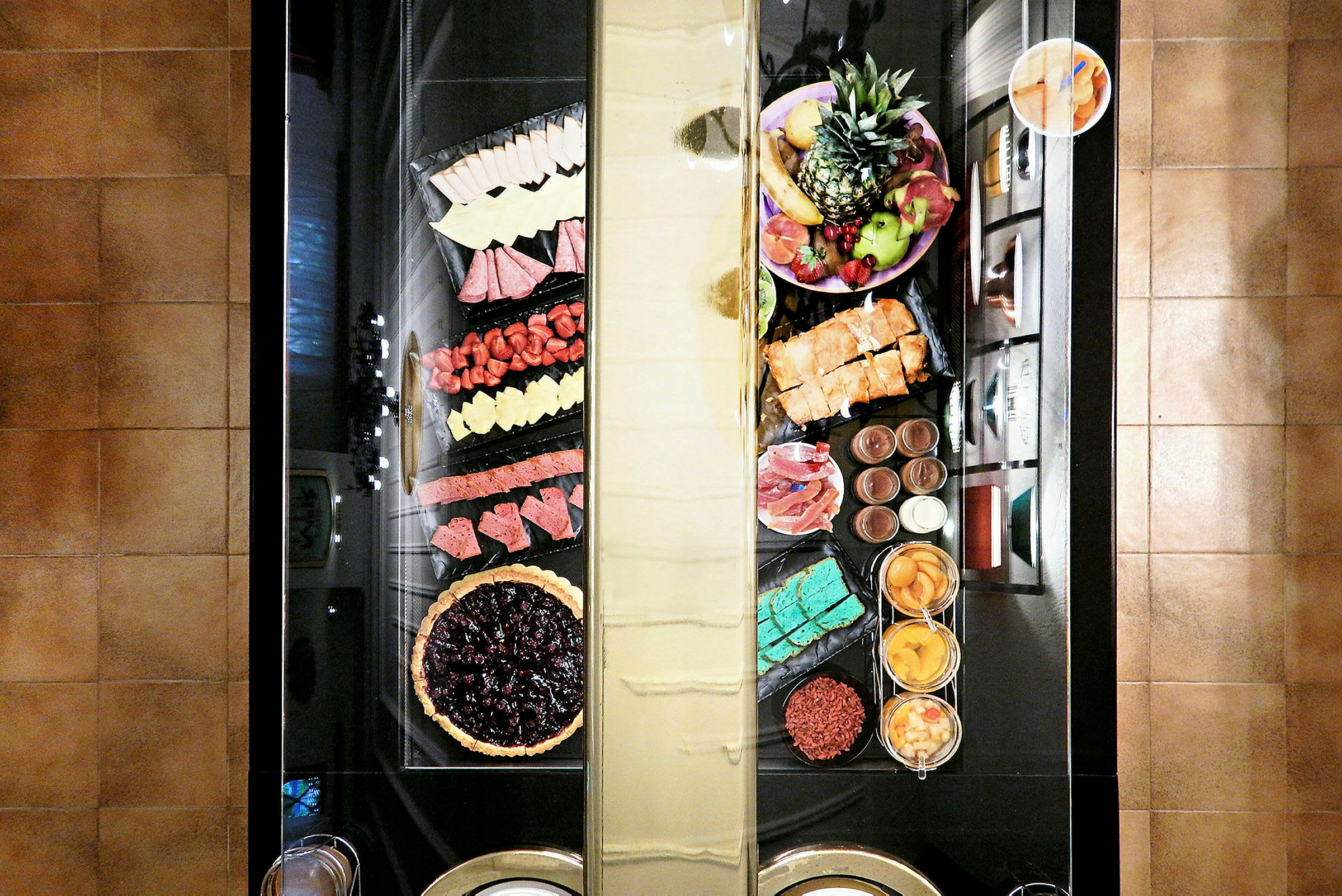 En buffé med olika maträtter och desserter, inklusive frukt och paj. (AI-genererad text)