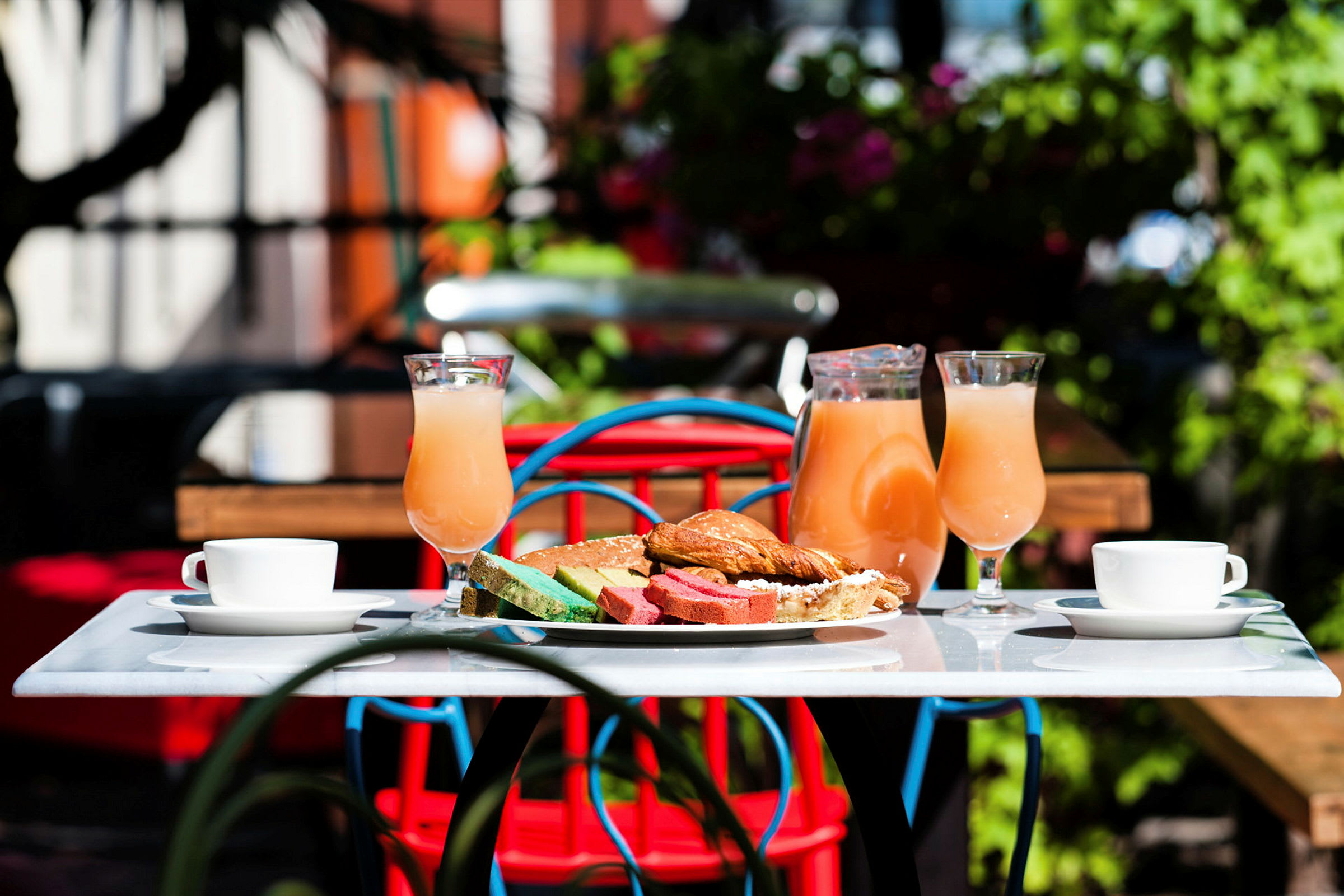 Ett bord med frukostmat, juice i glas och en kanna, samt kaffekoppar. (AI-genererad text)