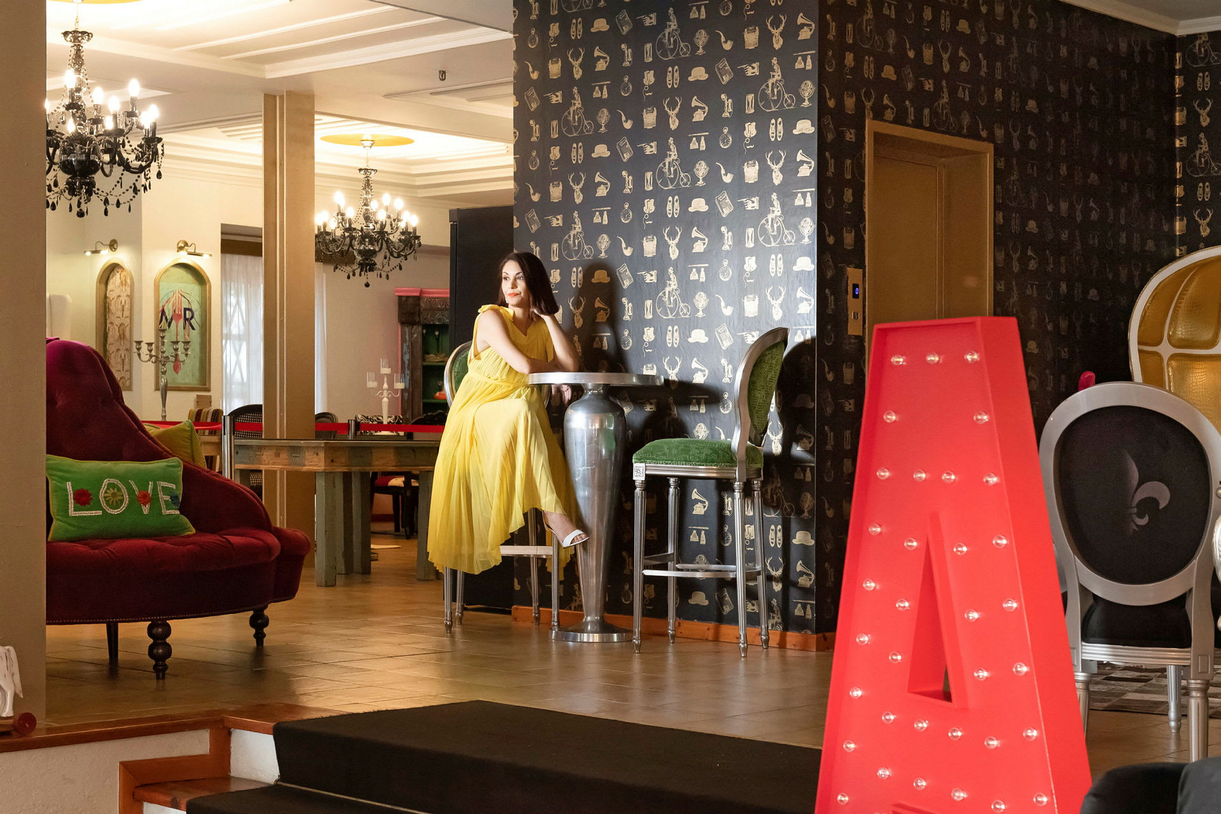 En interiör med eleganta möbler och dekorationer, inklusive en stor röd bokstav A. (AI-genererad text)