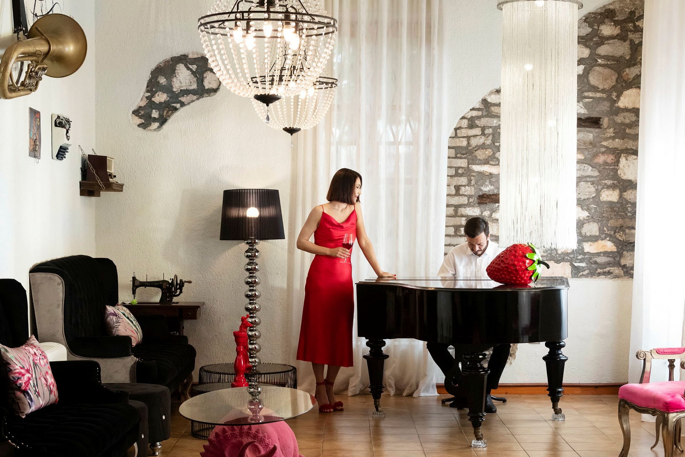 En kvinna i en röd klänning vid ett svart piano i ett elegant rum. (AI-genererad text)