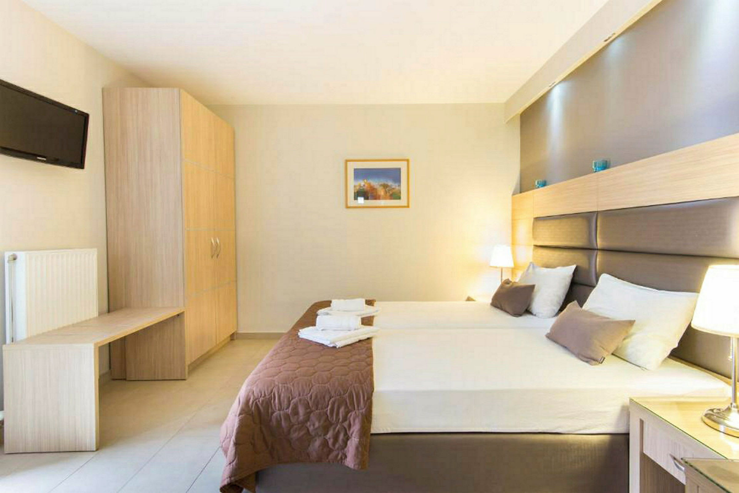 Ett hotellrum med två enkelsängar, sängbord och en garderob. (AI-genererad text)