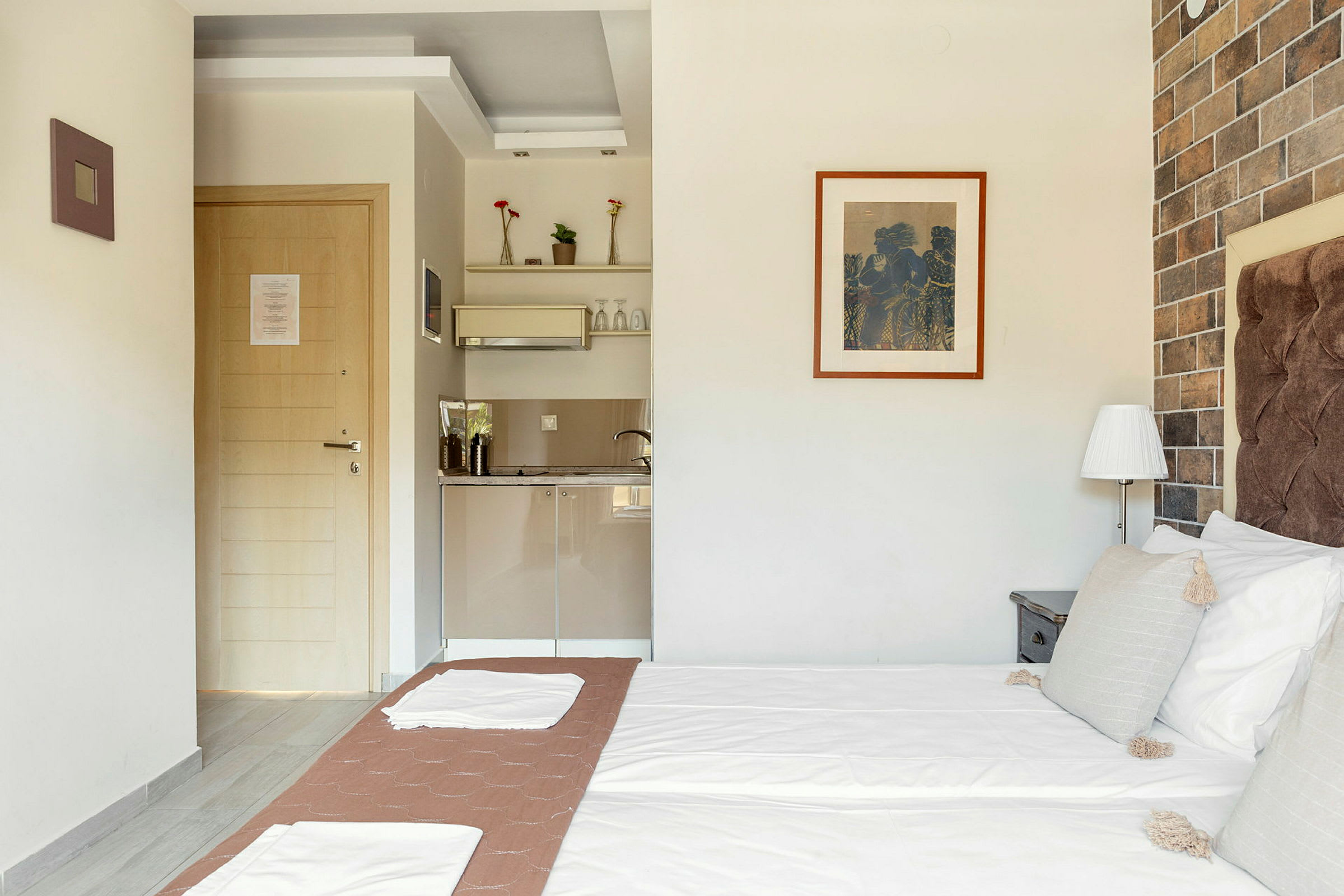 Ett hotellrum med en säng och ett pentry. (AI-genererad text)