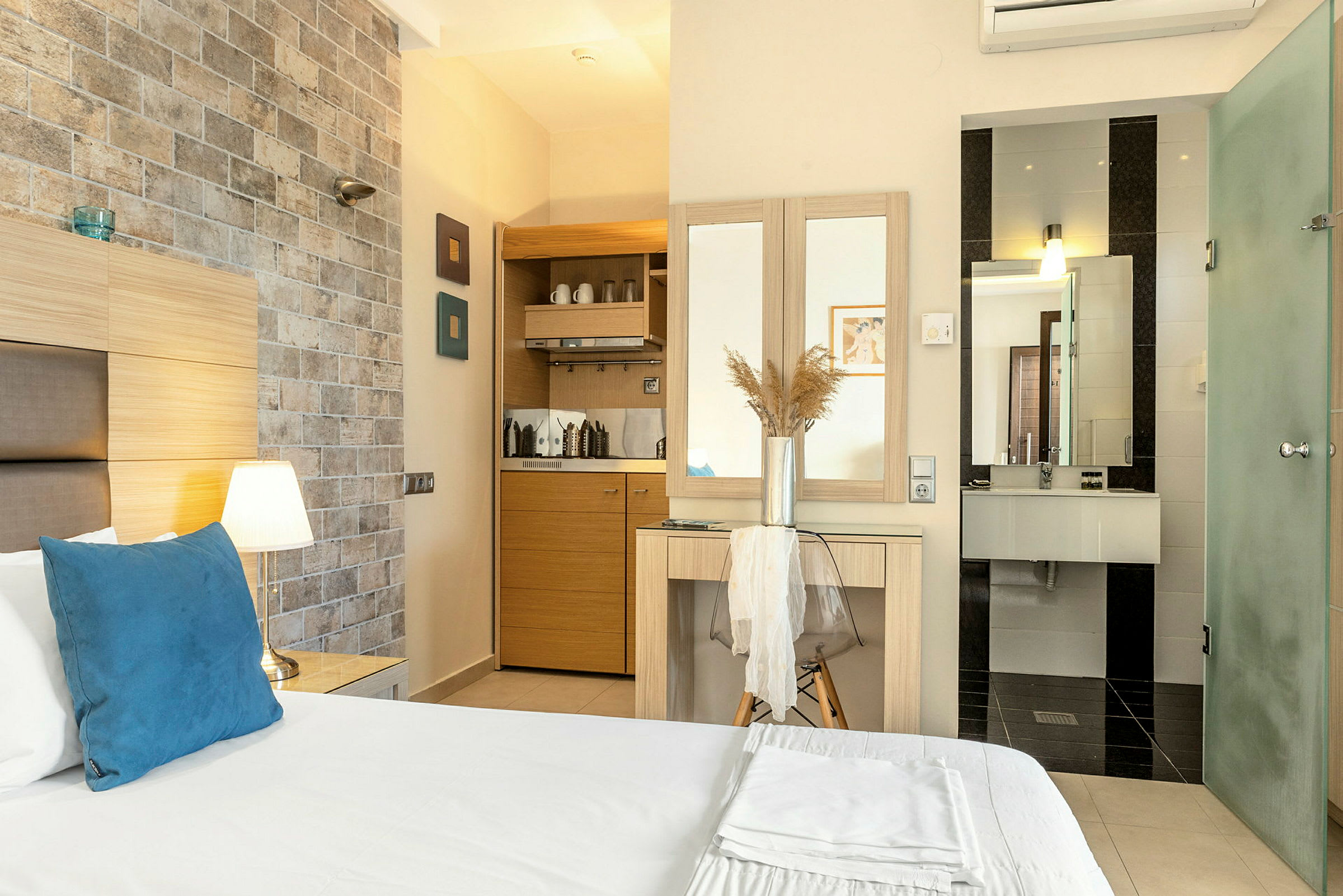 Hotellrum med säng, liten köksdel och badrum. (AI-genererad text)
