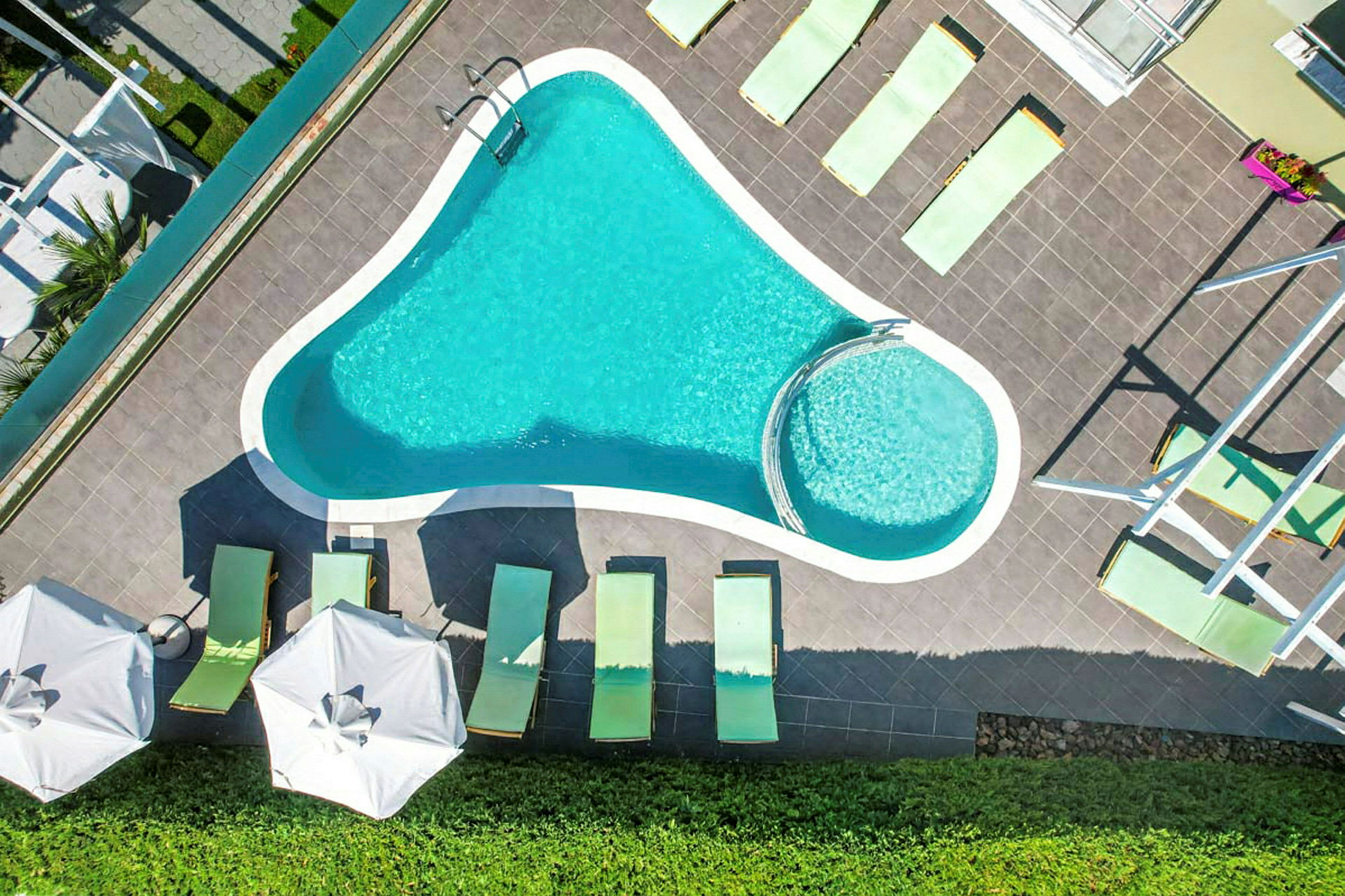 Bild av en pool med solstolar och parasoller runtom. (AI-genererad text)