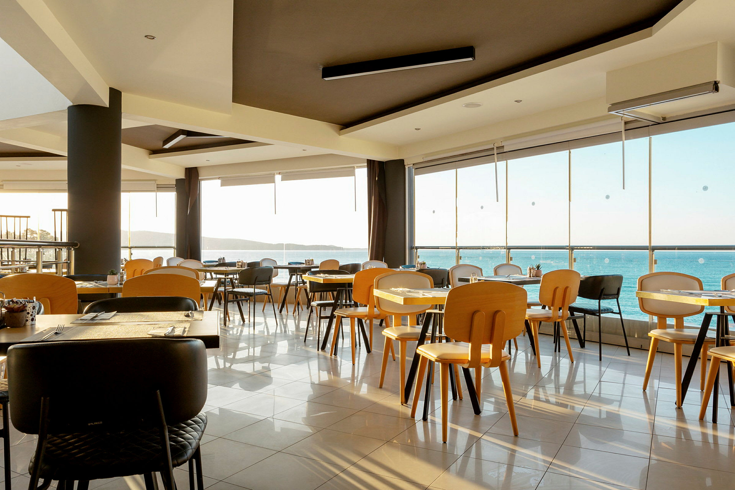 En restaurang interiör med utsikt över havet. (AI-genererad text)