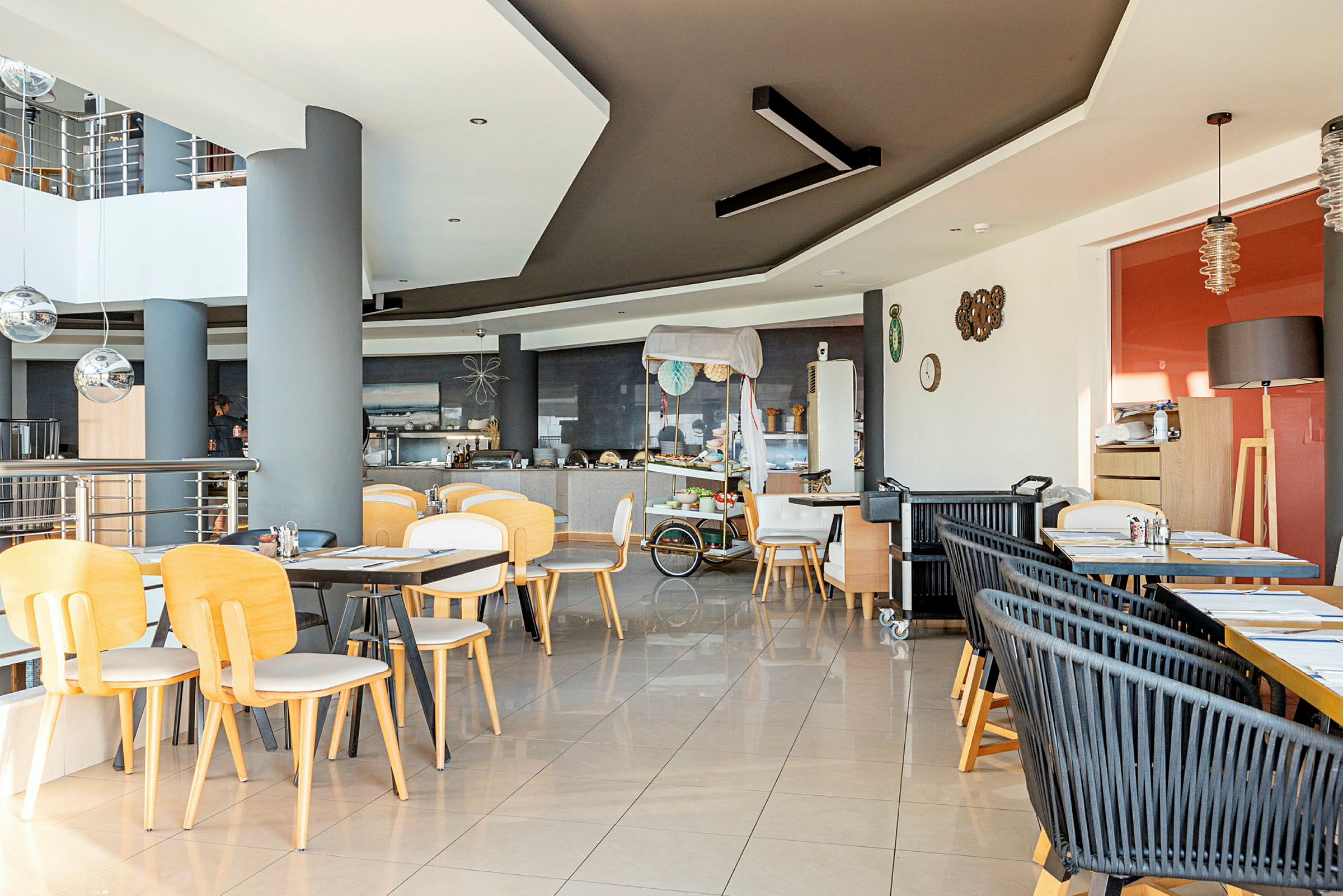 En restaurang med bord och stolar i trä, modern inredning och ett bufféområde. (AI-genererad text)