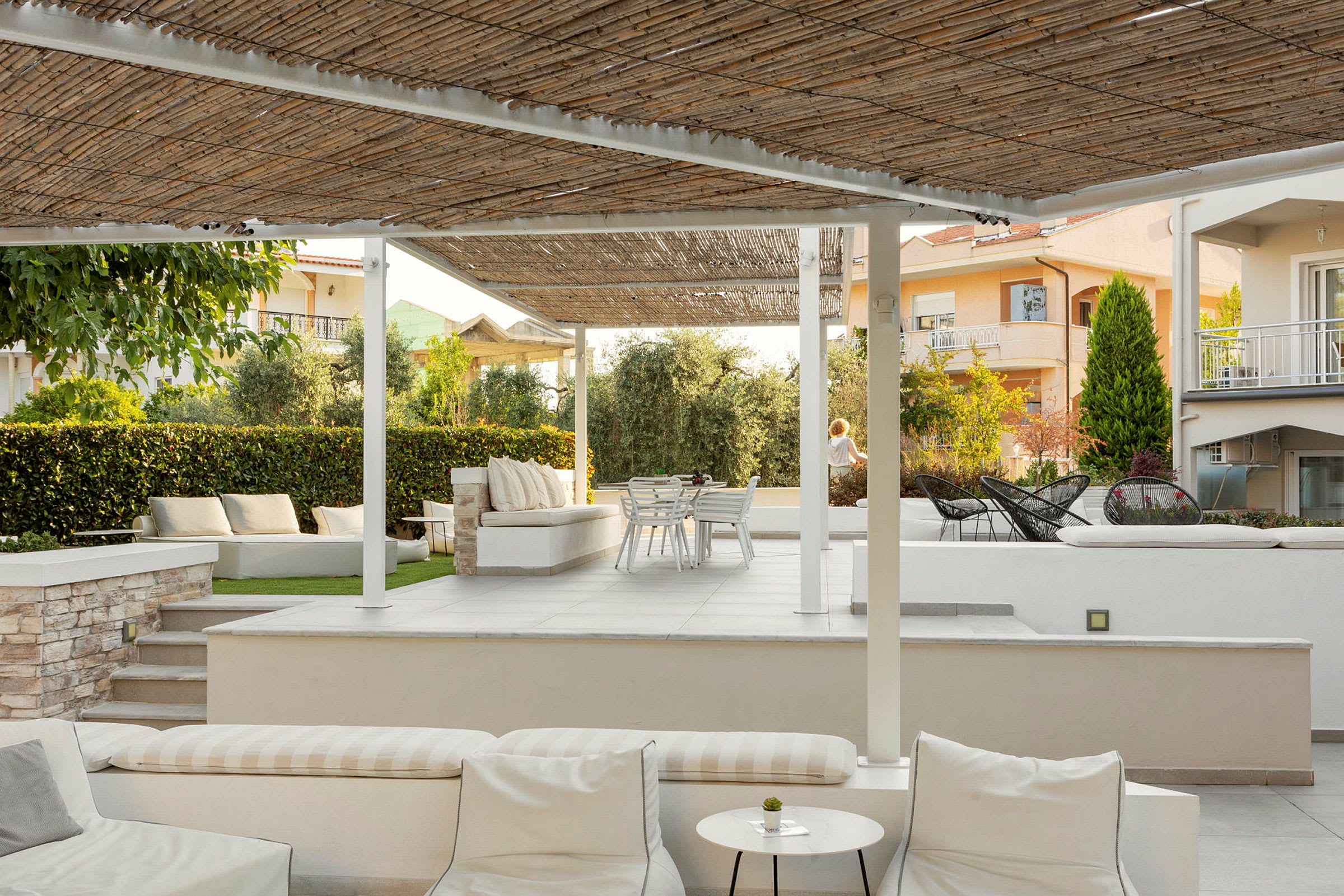 En terrass med sittplatser under pergola. (AI-genererad text)
