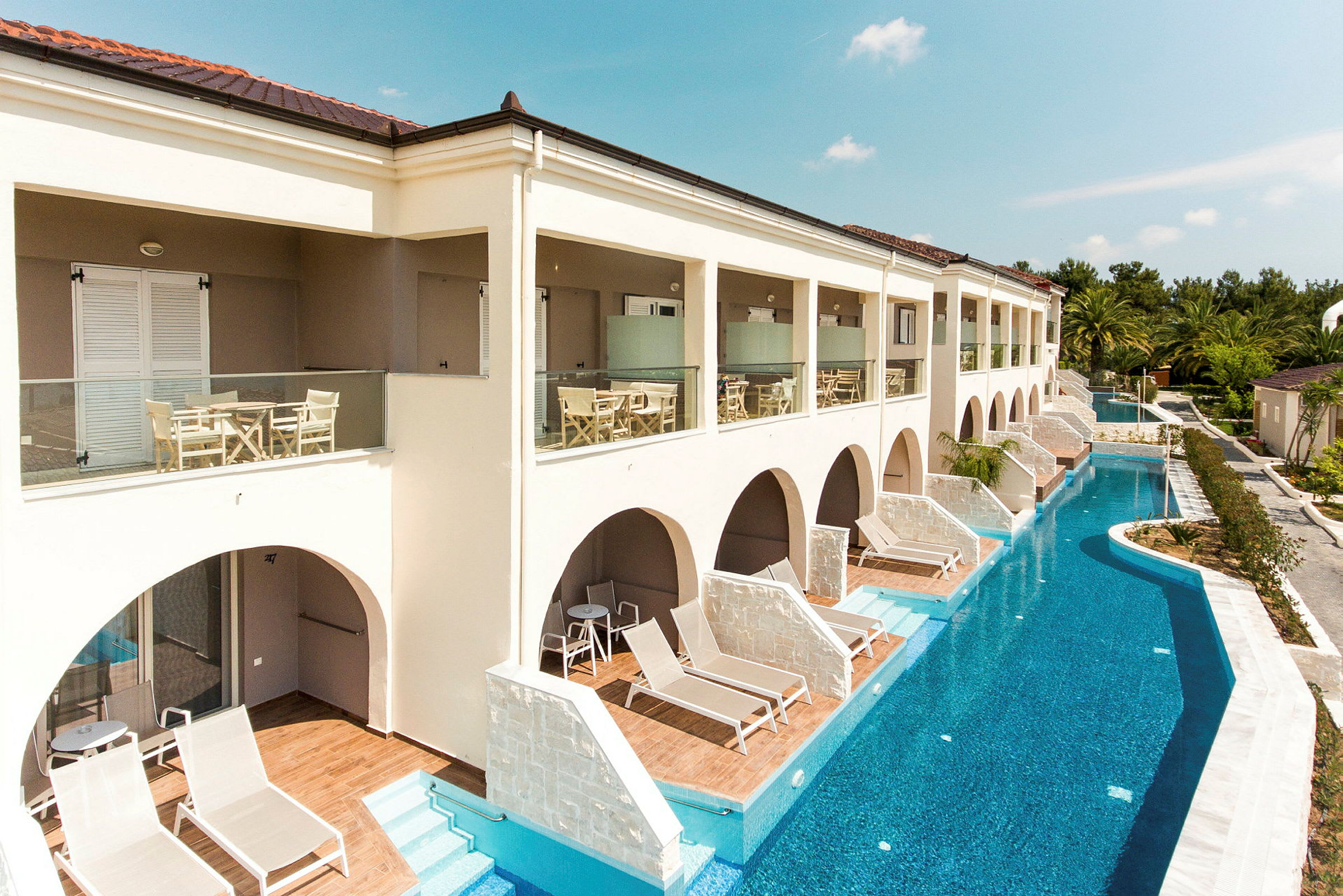 Bild på ett hotell med terrasser, solstolar och en pool. (AI-genererad text)