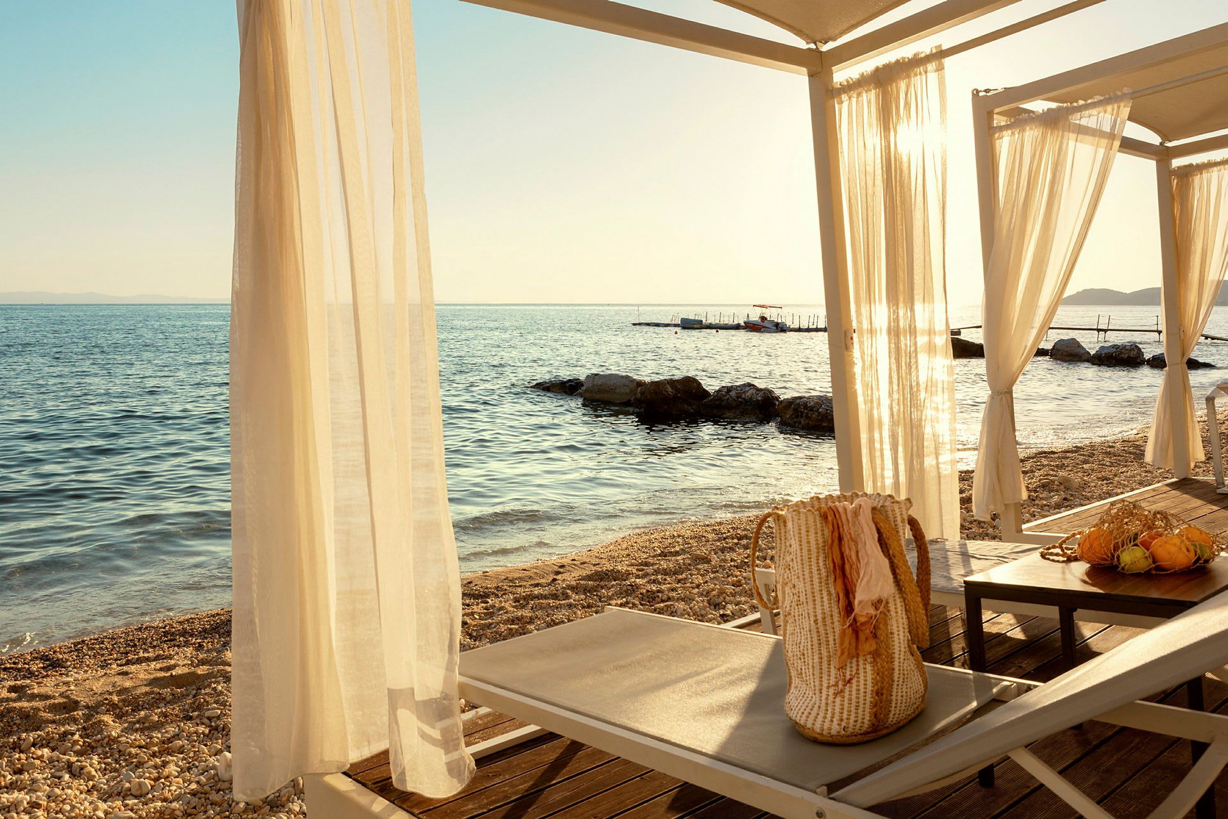Solstolar och bord under ett gazebo vid havet. (AI-genererad text)