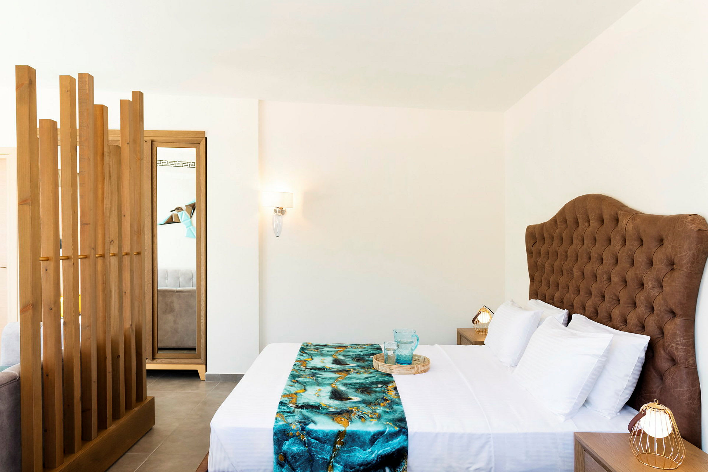Ett hotellrum med en dubbelsäng och en brun tuftad sänggavel. (AI-genererad text)