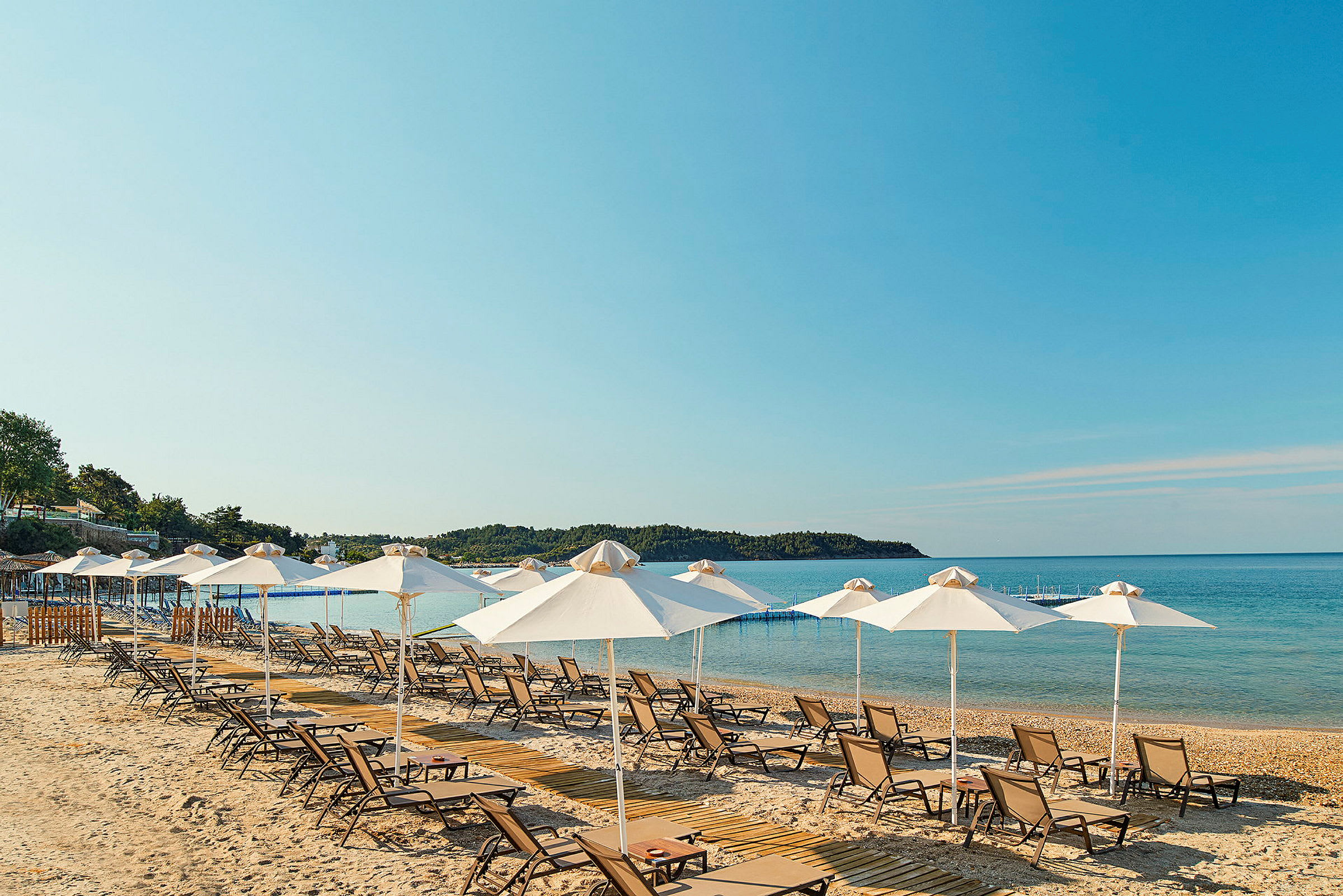 Strand med solstolar och parasoller vid havet. (AI-genererad text)