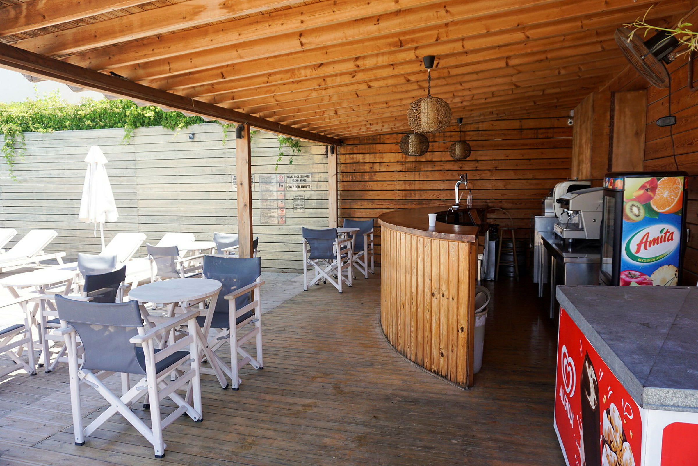 Utomhusservering med träbjälklag, bar och sittplatser. (AI-genererad text)