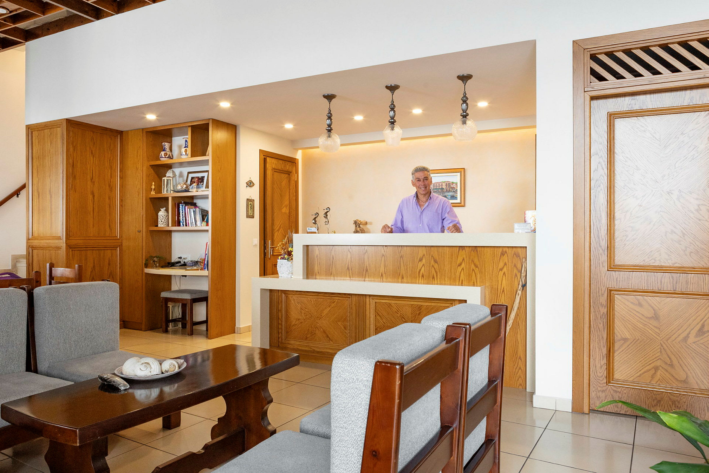 Receptionen i ett hotell med träinredning, soffor och bord framför. (AI-genererad text)