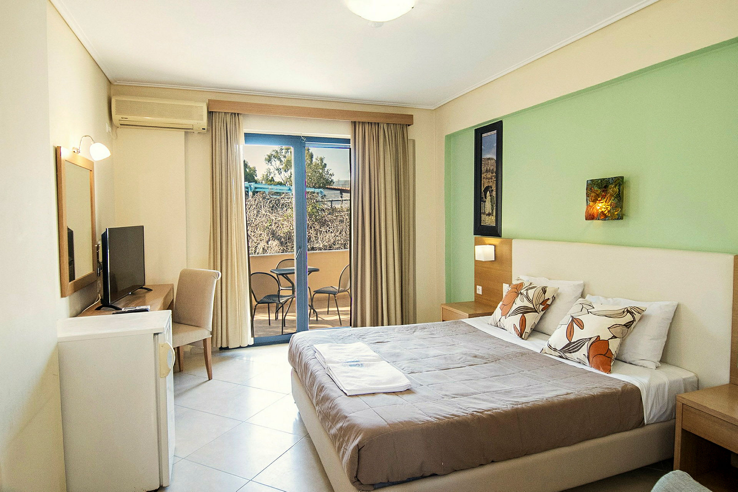 Hotellrum med stor säng, TV och balkong. (AI-genererad text)