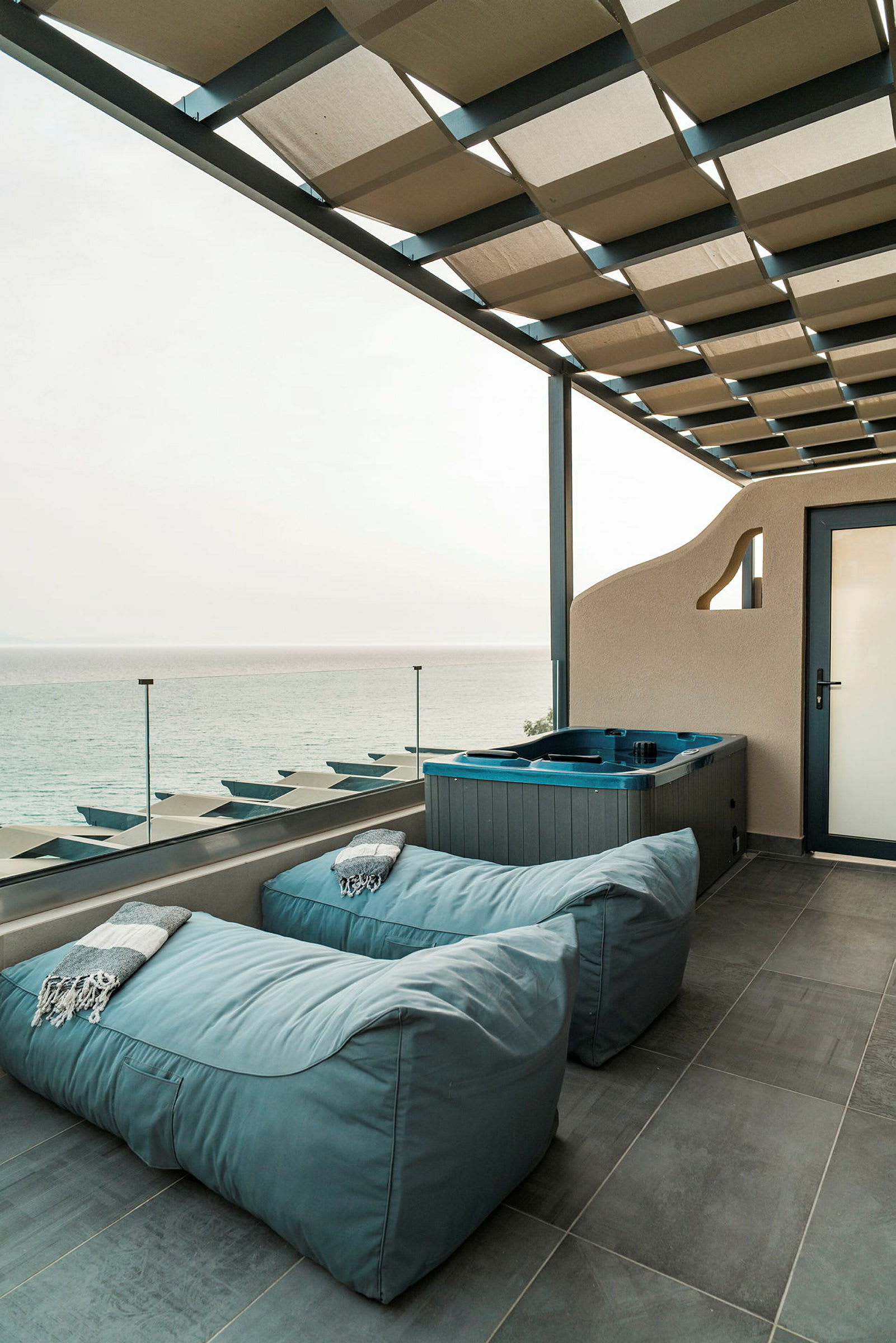 Terrass med sittmöbler och jacuzzi samt utsikt över havet. (AI-genererad text)