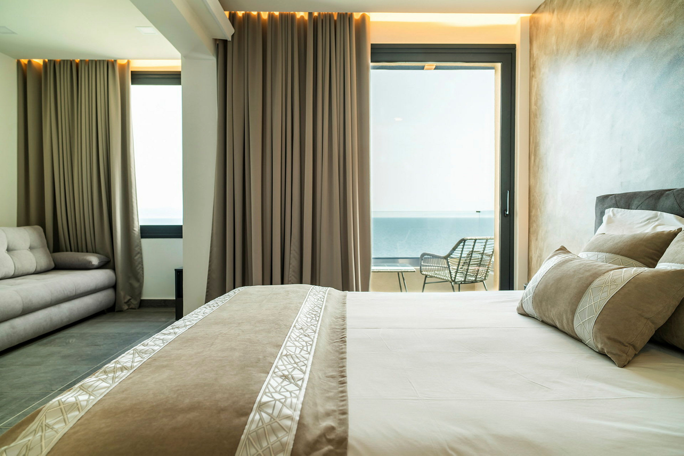 Hotellrum med säng, soffa och balkong. (AI-genererad text)