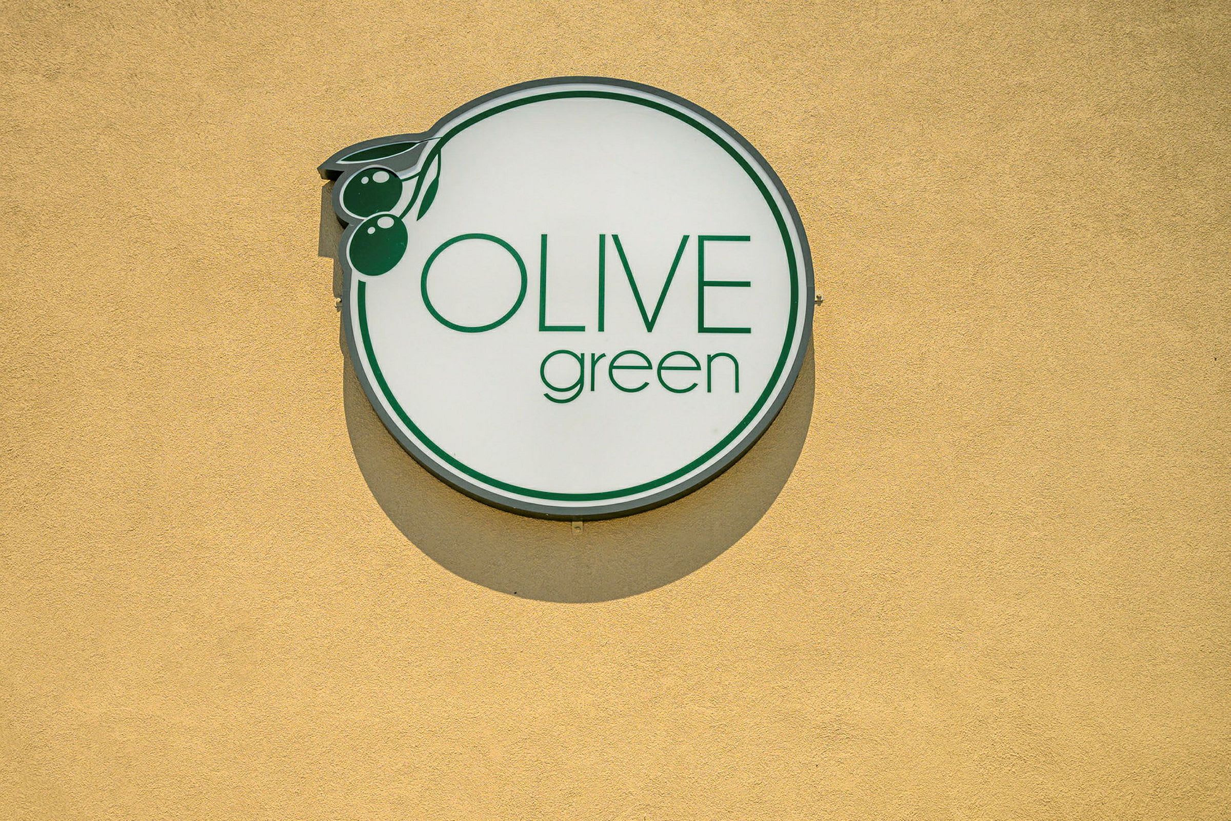 Skylt med texten 'Olive Green' på gul bakgrund. (AI-genererad text)