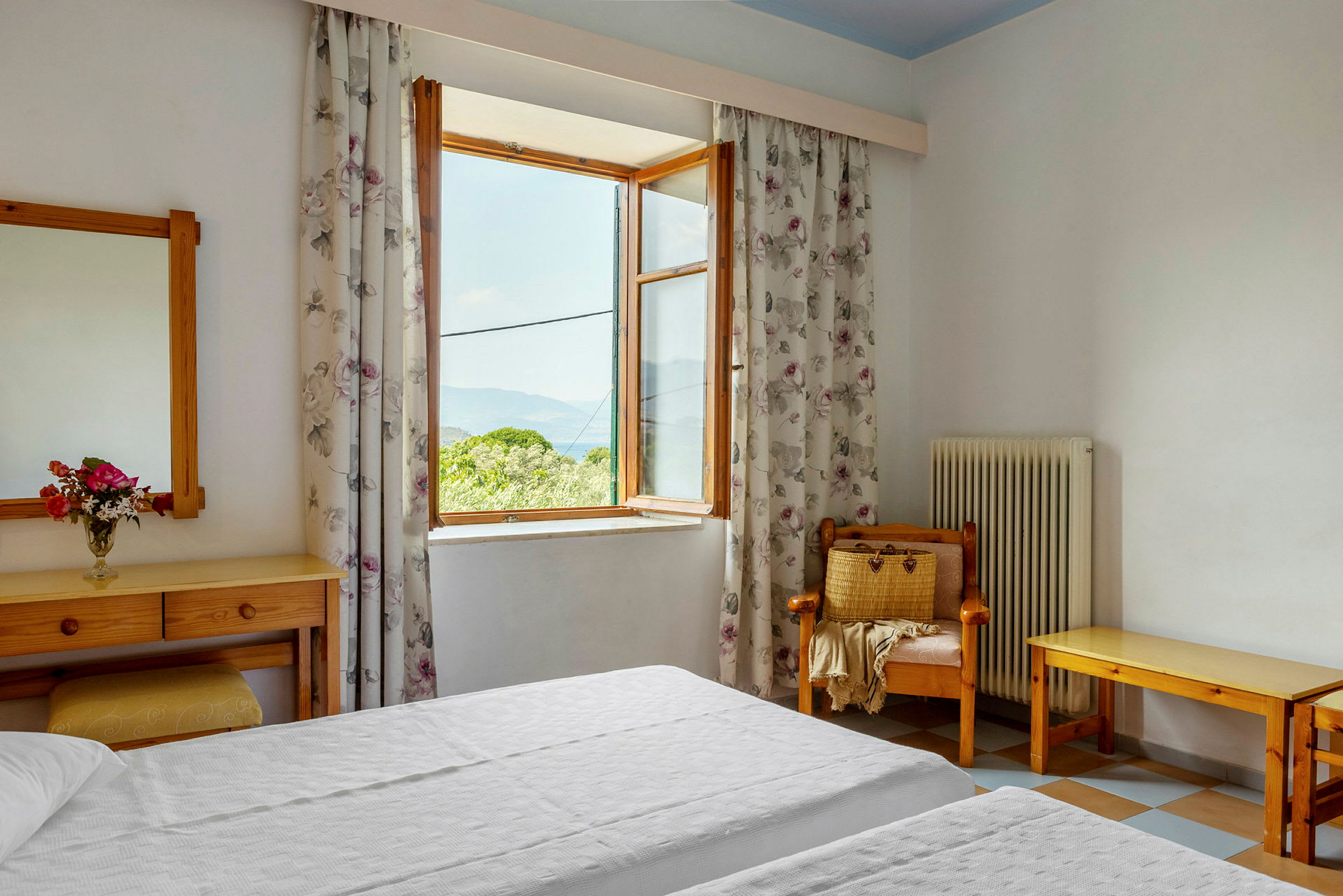 Ett hotellrum med ett öppet fönster och två enkelsängar. (AI-genererad text)