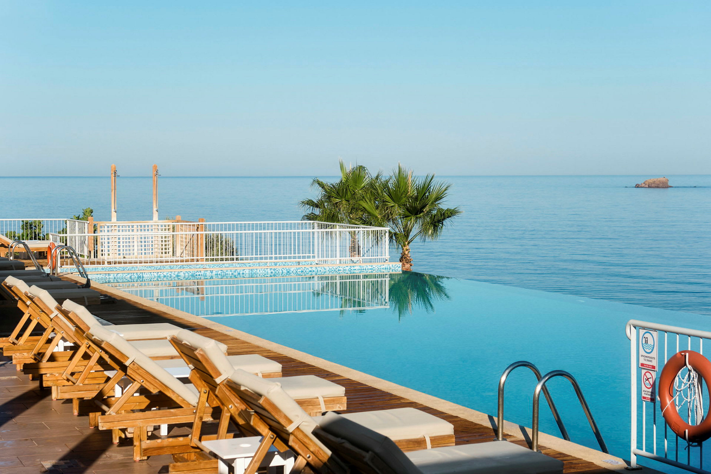 En infinitypool med solstolar intill och med utsikt över havet. (AI-genererad text)