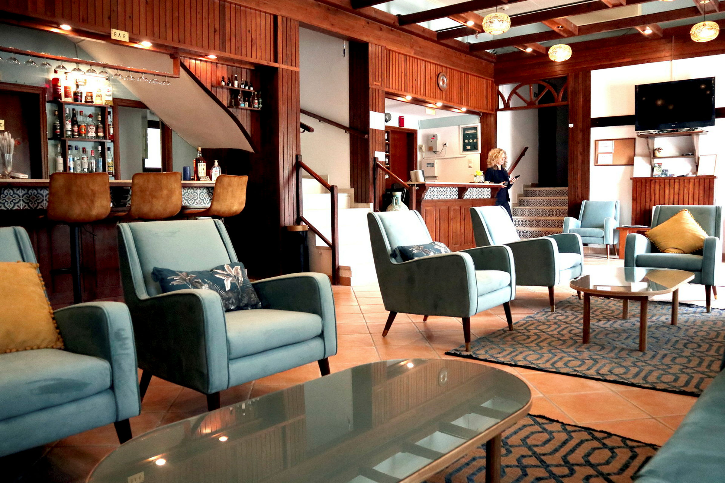 Interiör av ett hotell med blå stolar, bar och reception. (AI-genererad text)