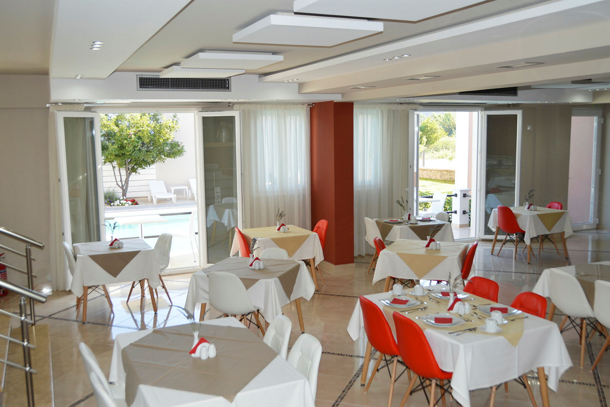 Restaurang med dukade bord och utsikt mot en utomhuspool. (AI-genererad text)