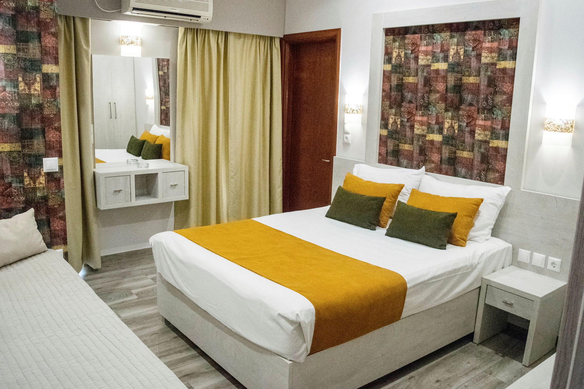 Hotellrum med en dubbelsäng och inredning i jordnära färger. (AI-genererad text)