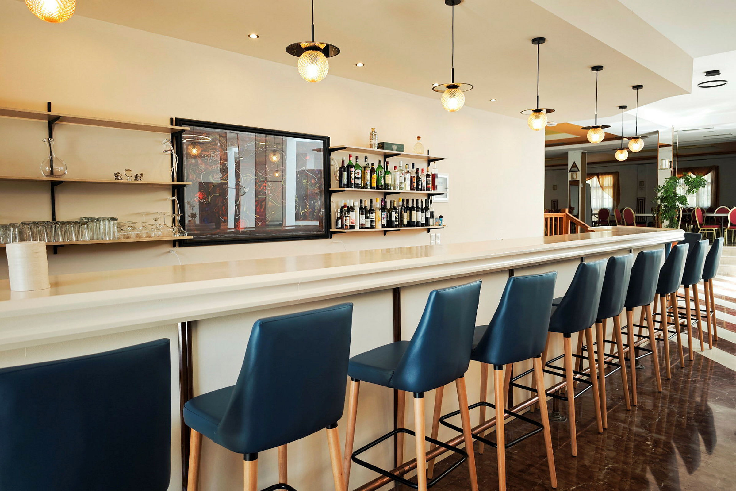 En ljus hotellbar med blå barstolar. (AI-genererad text)