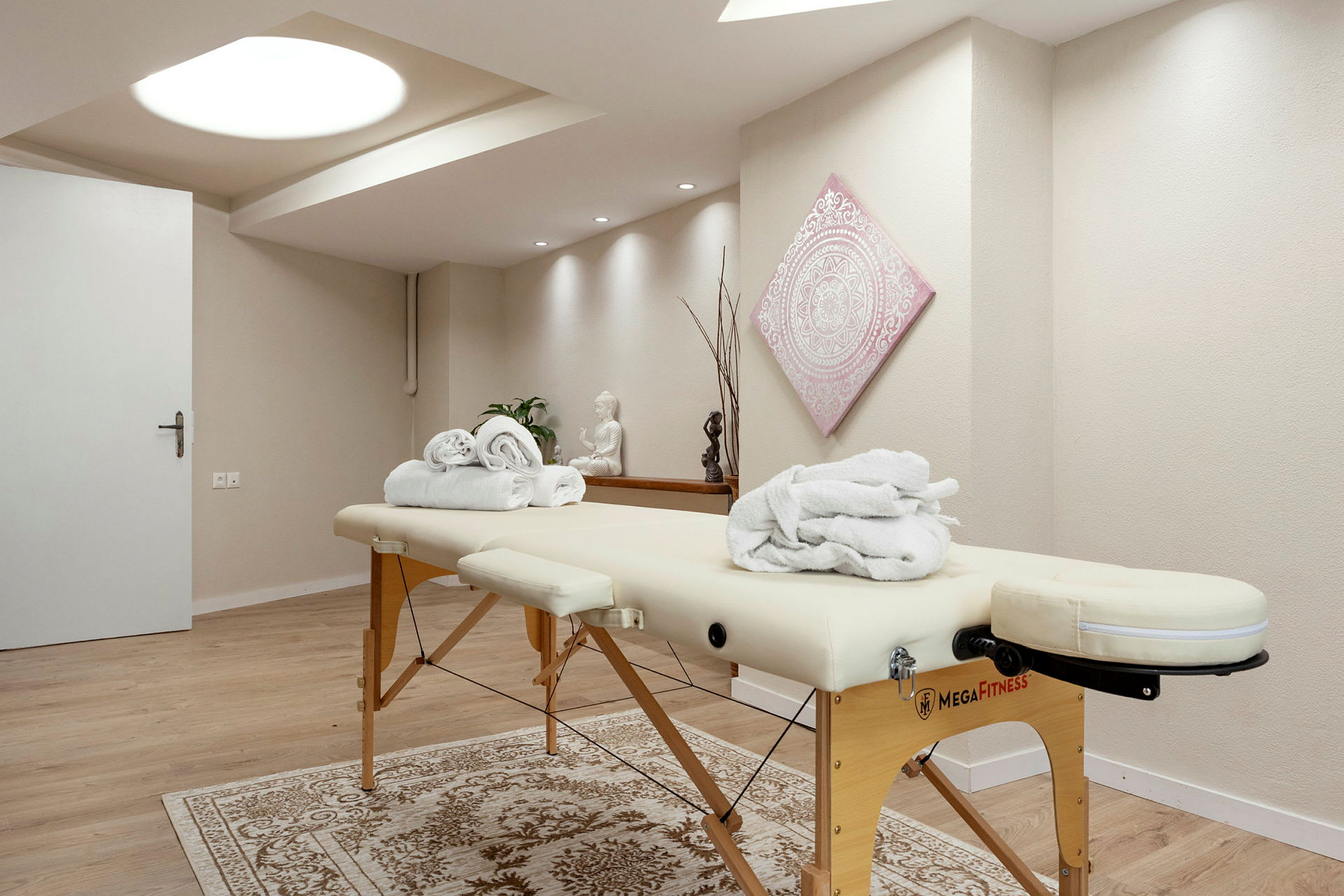 Massagebänk i ett rum med ljus inredning. (AI-genererad text)