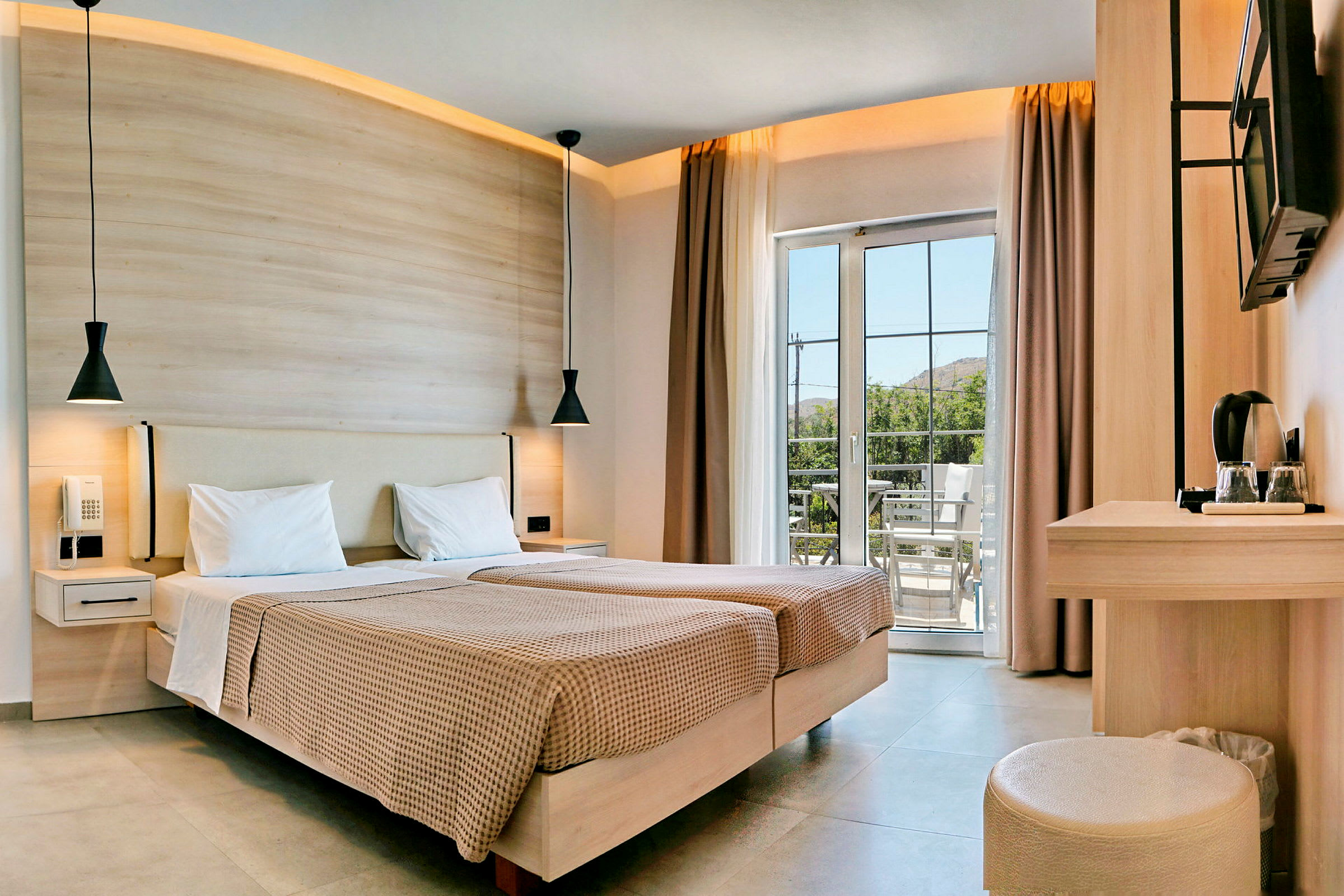 Modernt hotellrum med två enkelsängar, skrivbord och balkong. (AI-genererad text)