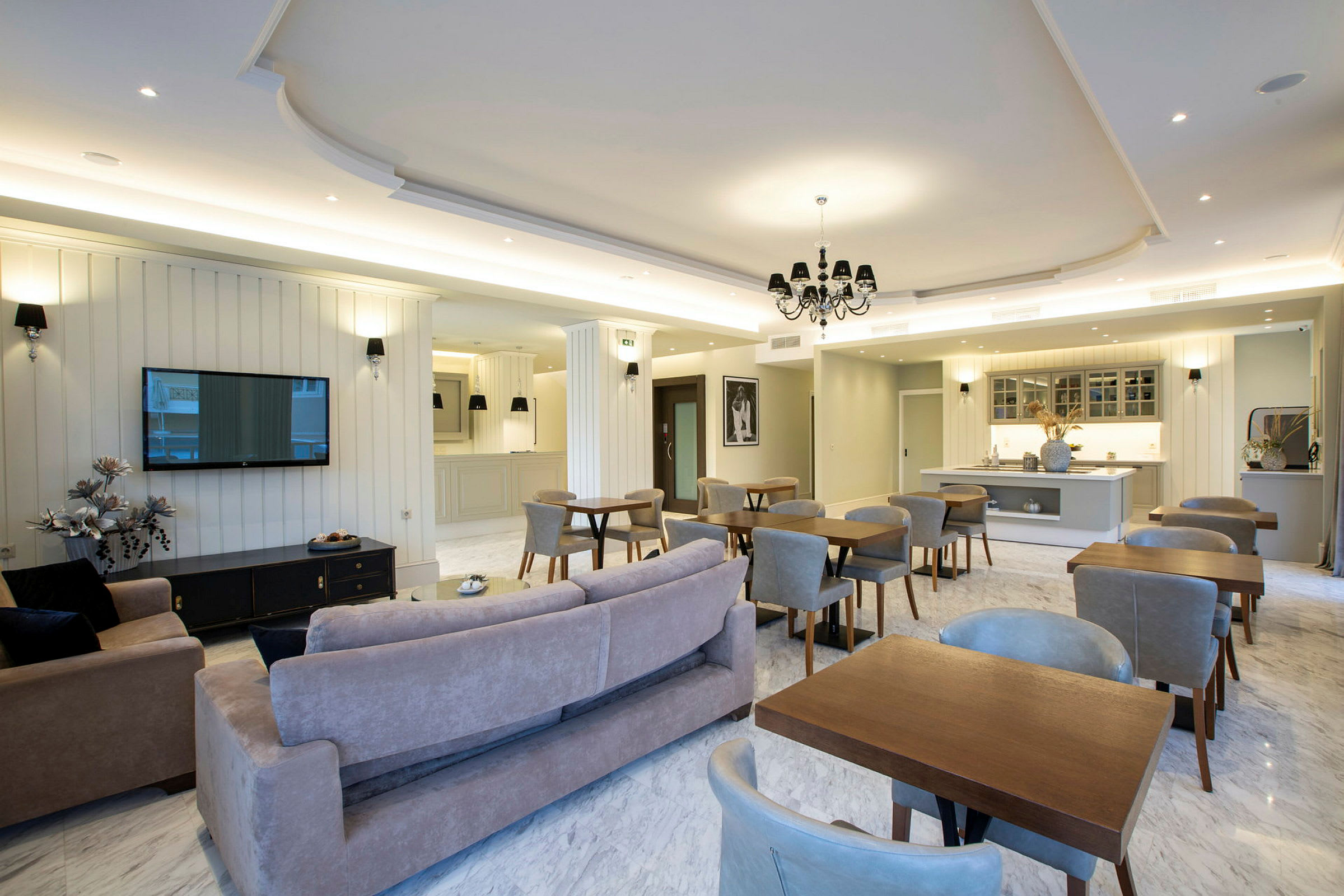 En rymlig inomhuslounge med sittgrupper och ett köksområde i elegant modern stil. (AI-genererad text)